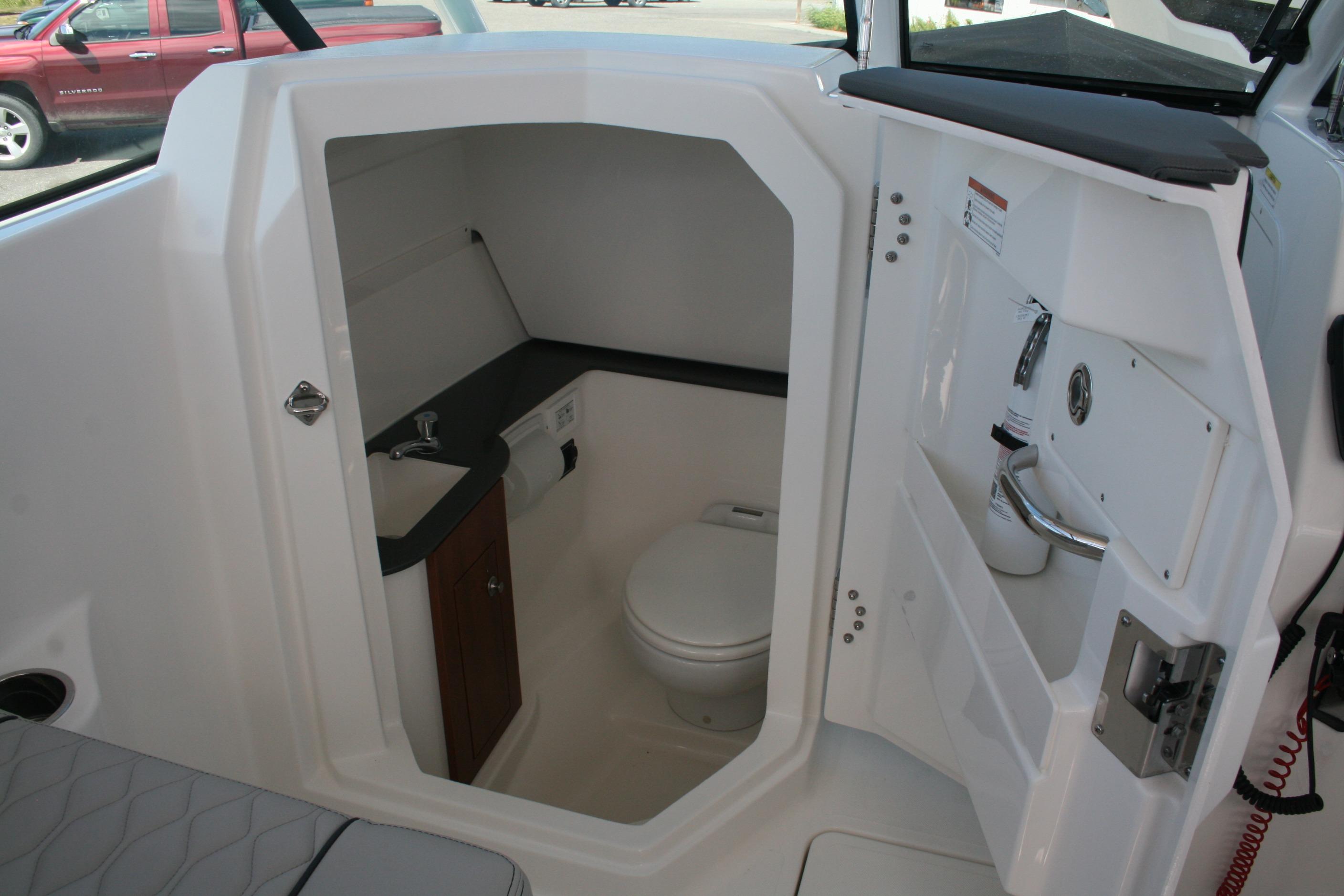 Interior of 2026 Pursuit DC 266 Dual Console boat's compact bathroom.