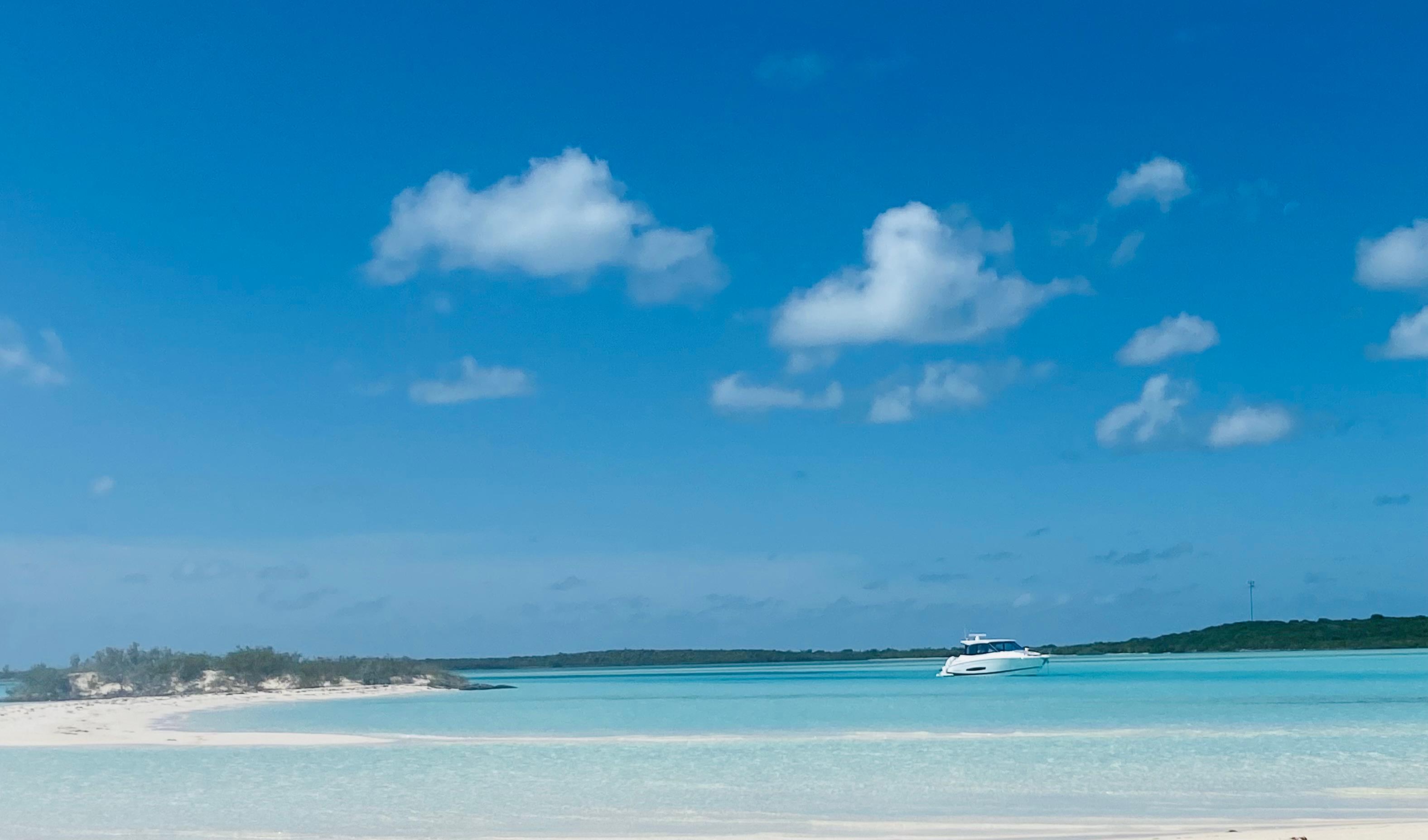 2023 Regal 36 XO yacht cruising in clear blue tropical waters under a bright sky.