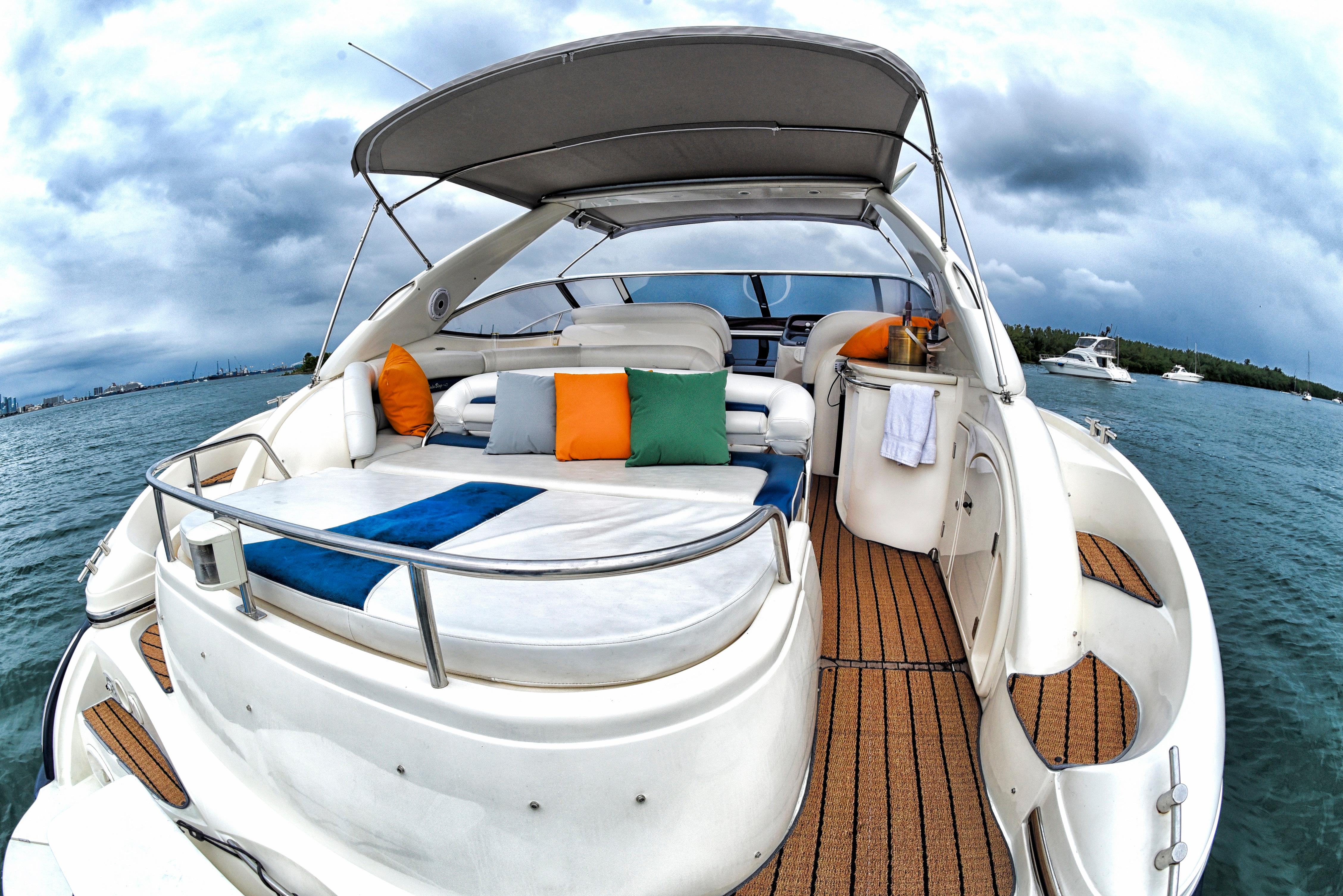 Sunseeker 44 Camargue 2001 yacht with spacious deck and colorful cushions on the water.