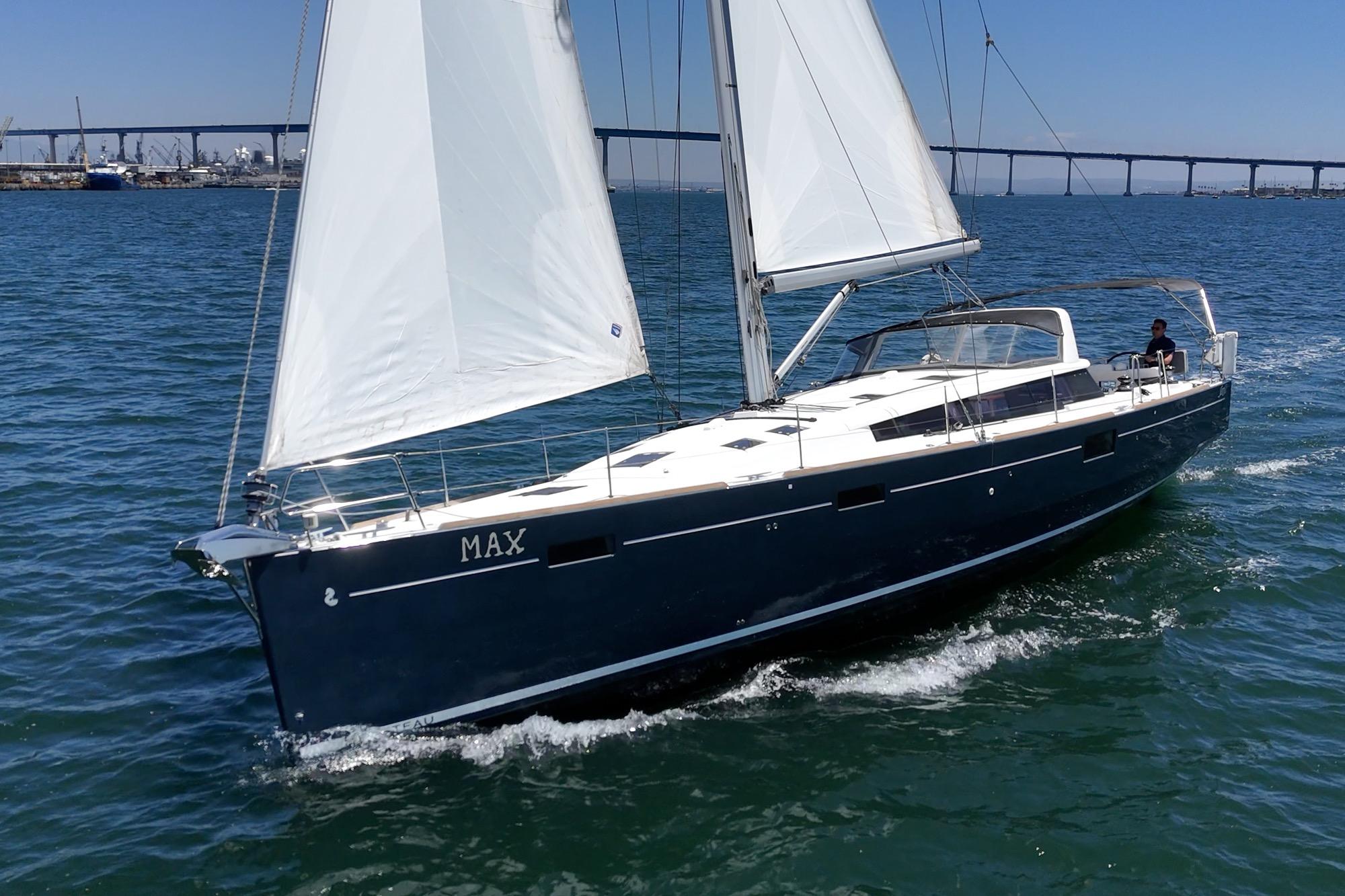 2017 Beneteau Sense 50 sailboat cruising on open water with bridge in background.