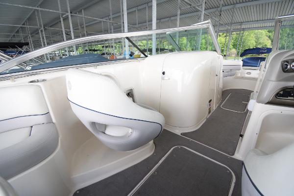The image shows the interior of a 2010 Bryant 255 boat with white seats and gray flooring.