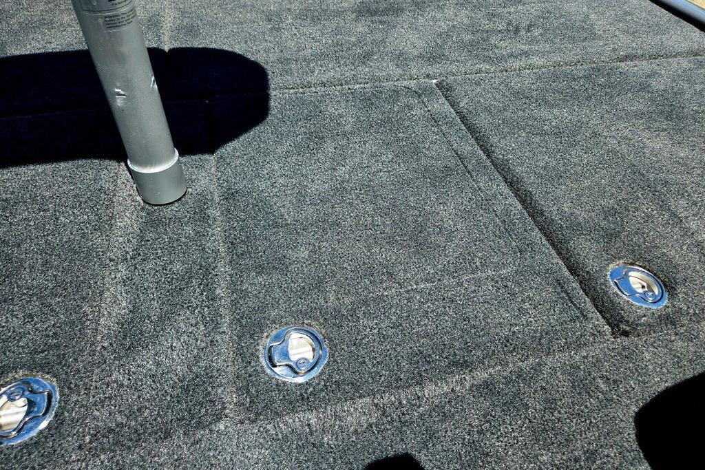 Carpeted deck of 2026 Skeeter ZXE20 boat with metal fixtures and pole.