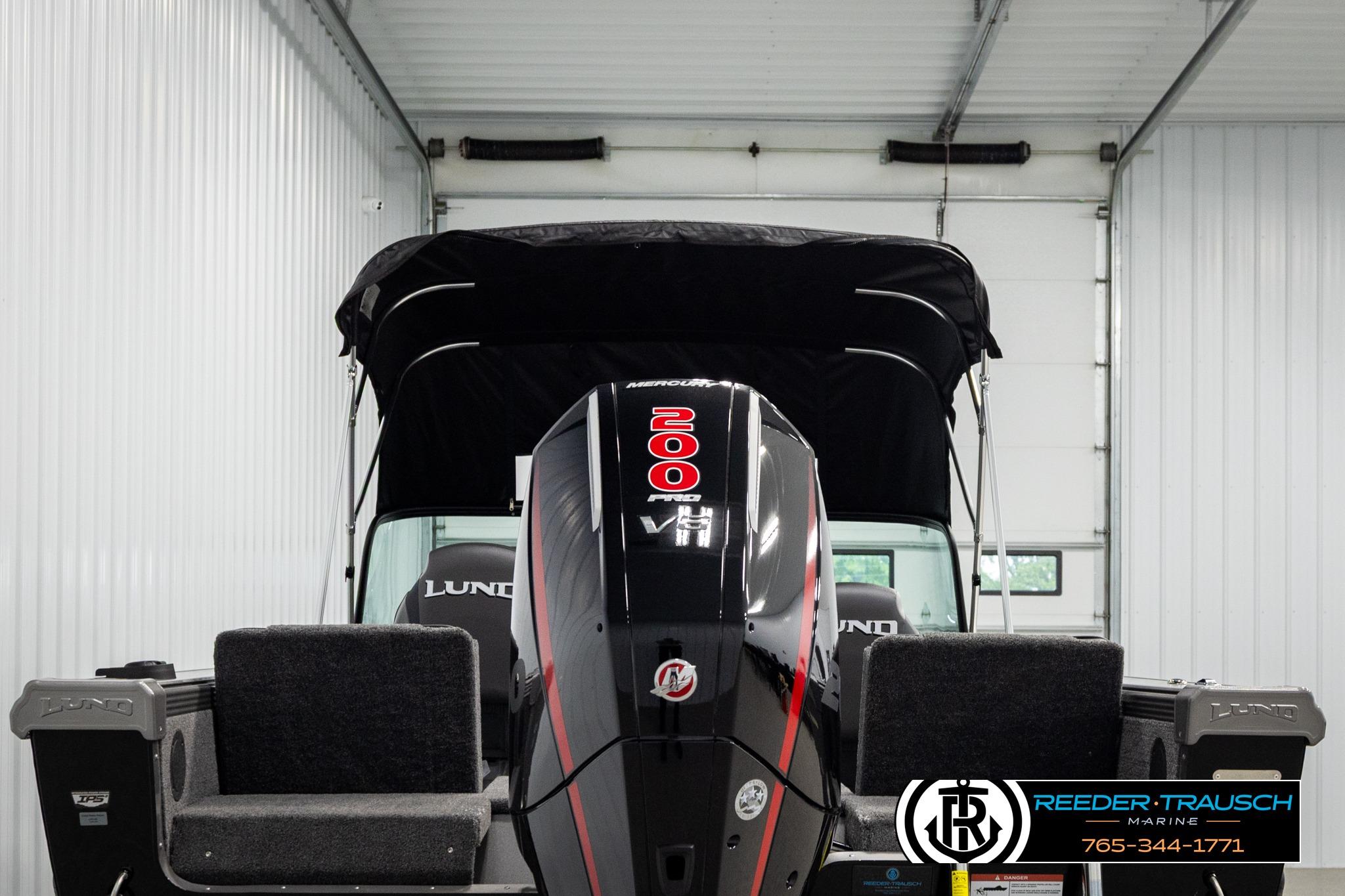 2026 Lund 1975 Tyee boat with 200 HP Mercury engine in a showroom.