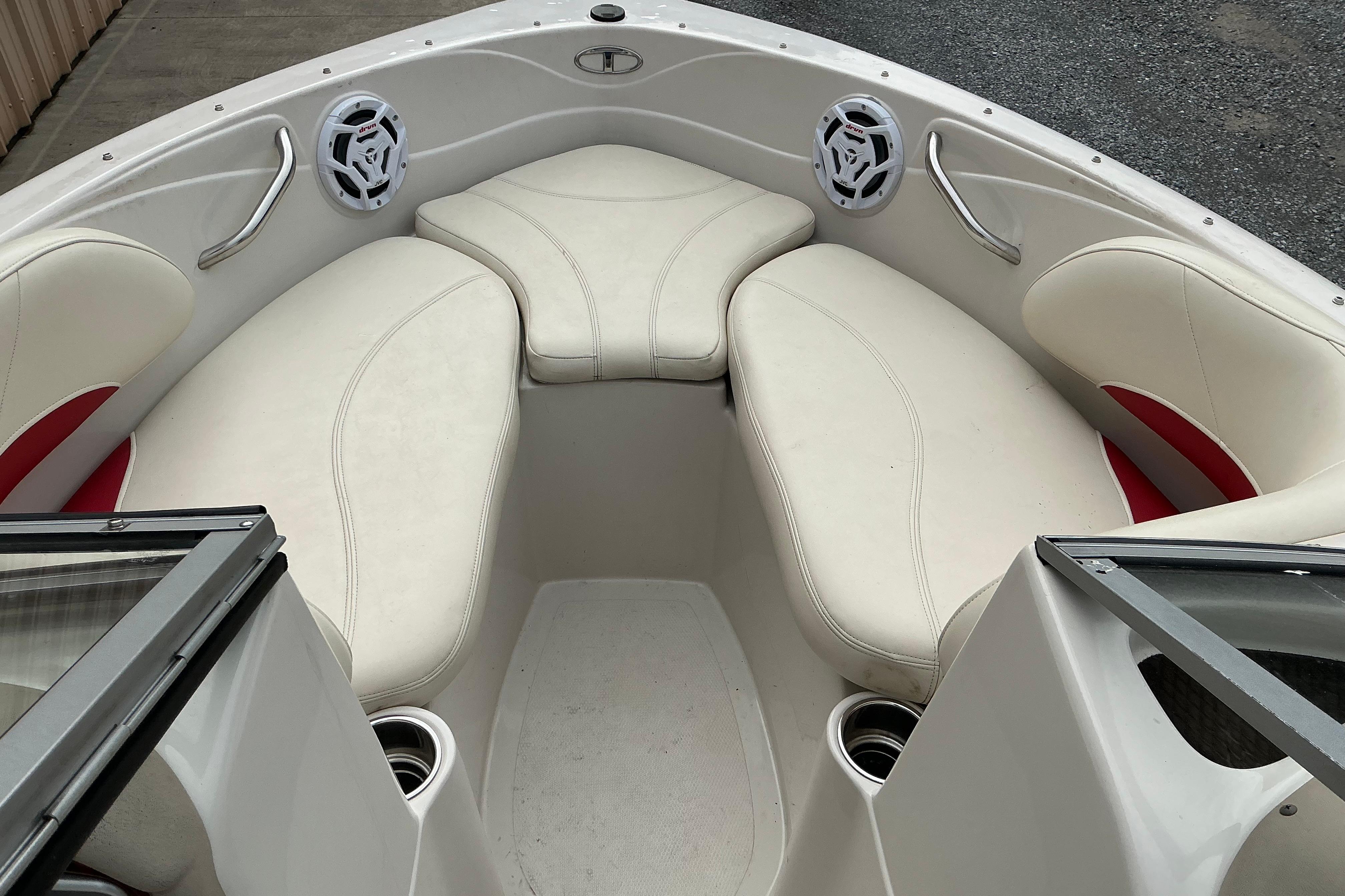 Interior of a 2014 Tahoe Q7i boat with white cushioned seating and speakers.