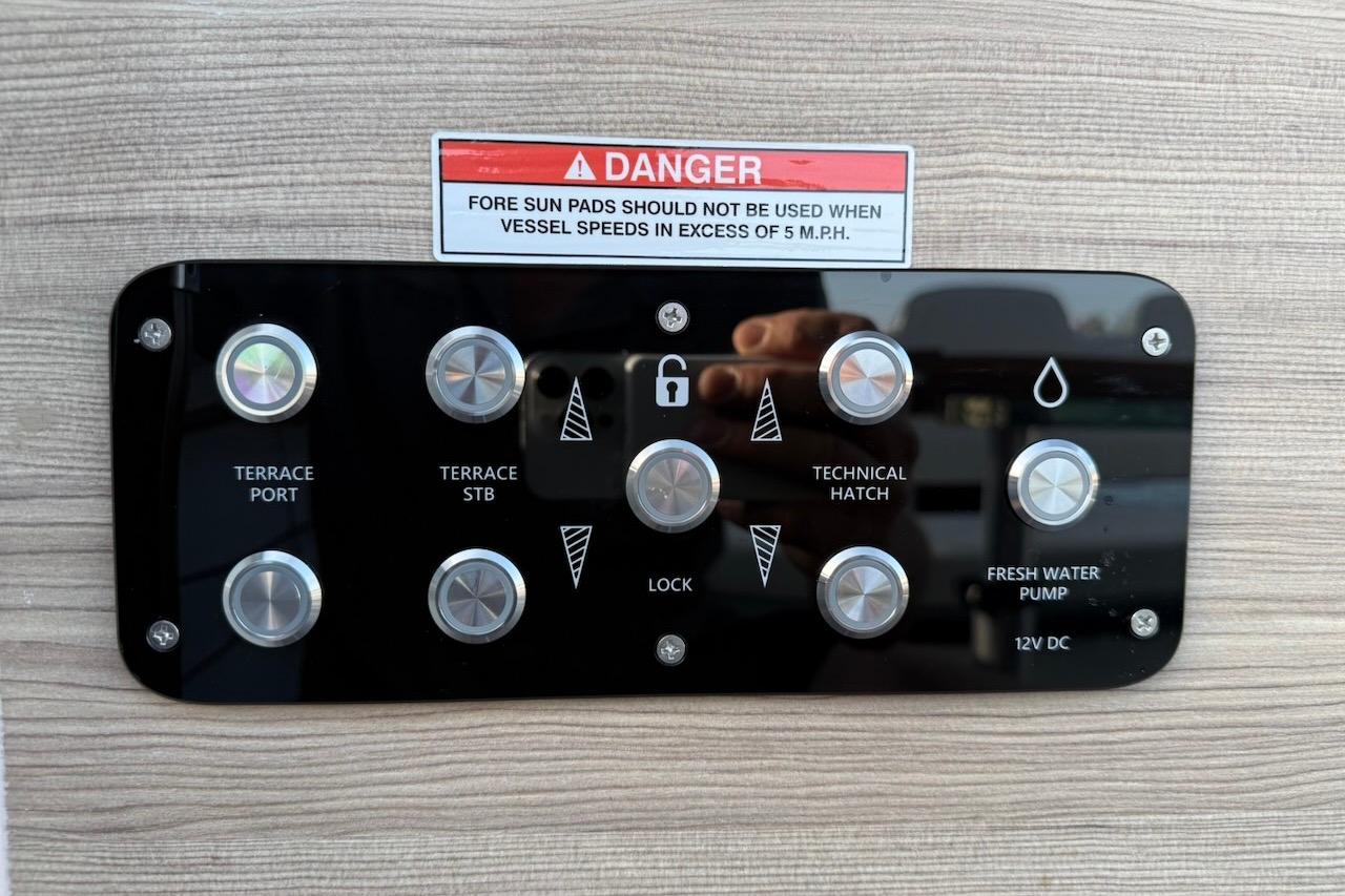 Control panel on 2024 Saxdor 320 GTC boat with warning label and various buttons.