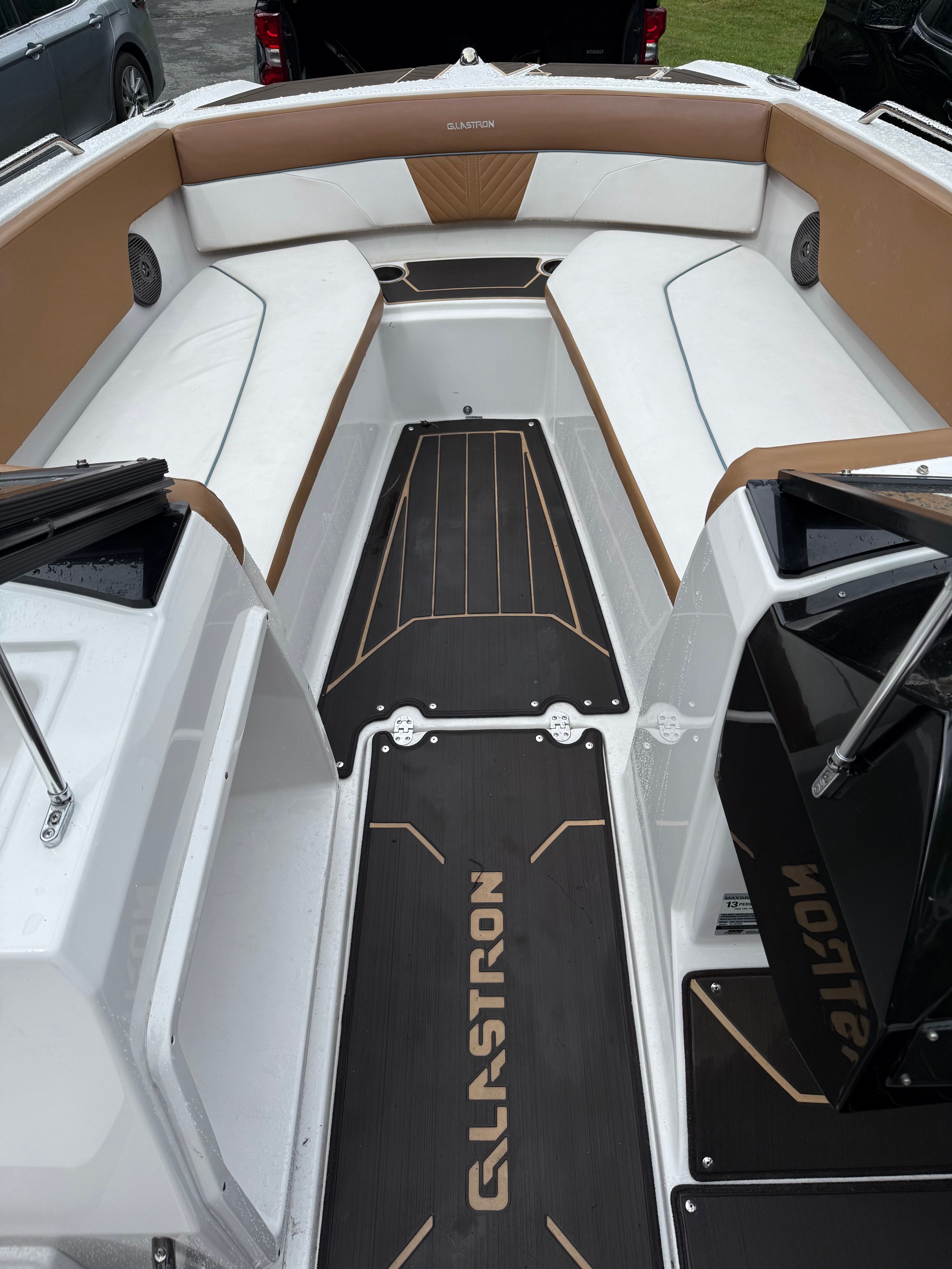 The image shows the cockpit of a 2019 Glastron GTDW 225 with white and brown seating.