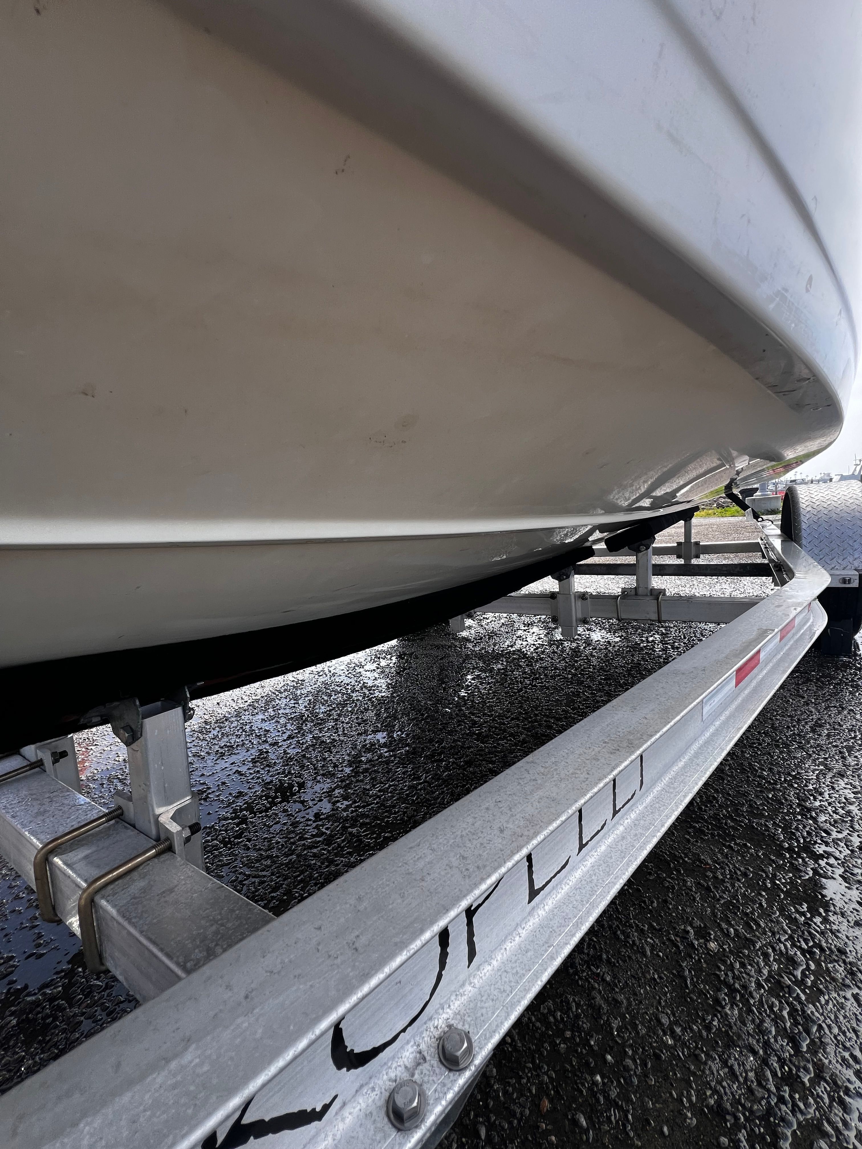 Close-up of a white boat's hull on a trailer.