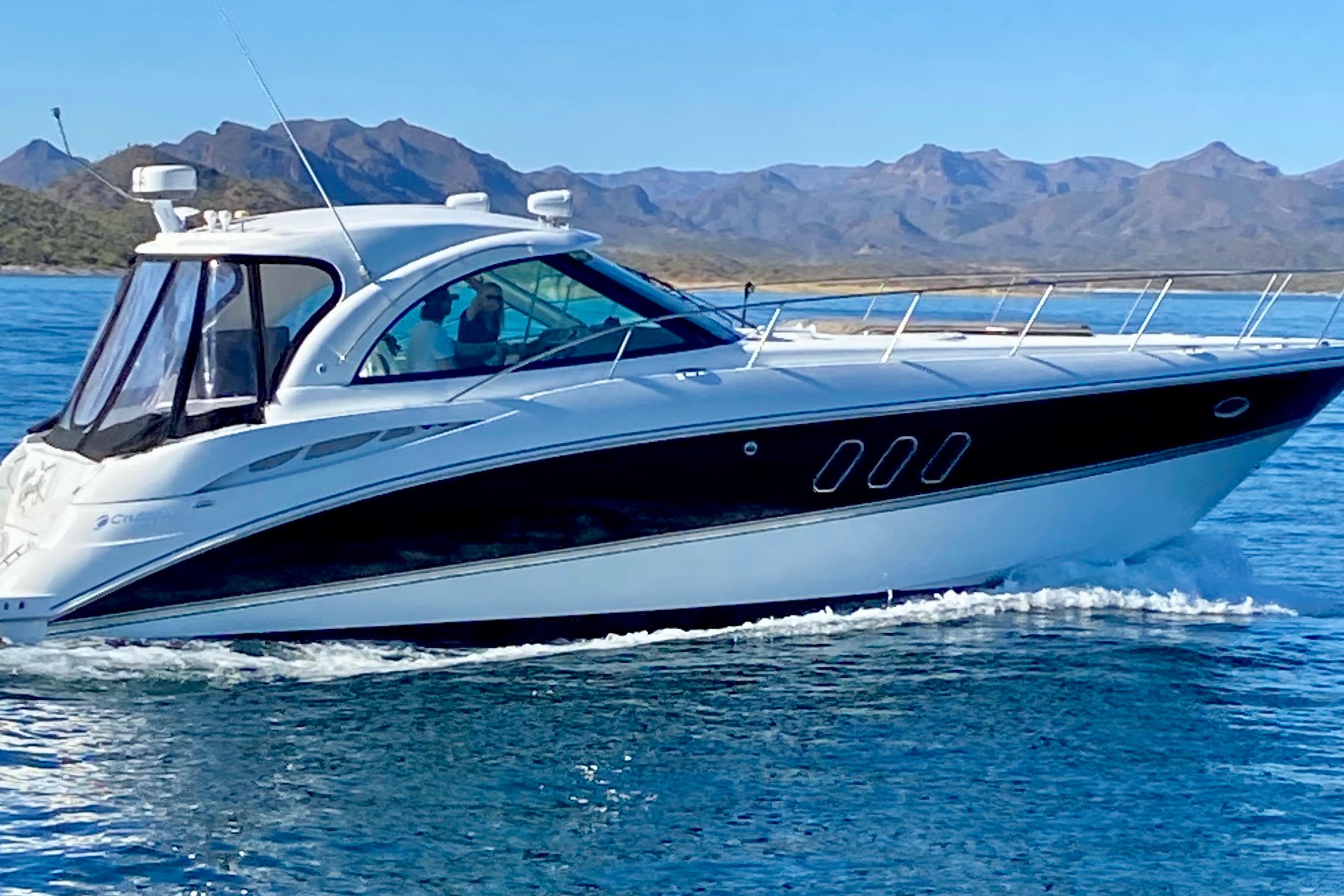 2011 Cruisers Yachts 390 Sports Coupe sailing on a serene lake with mountain backdrop.