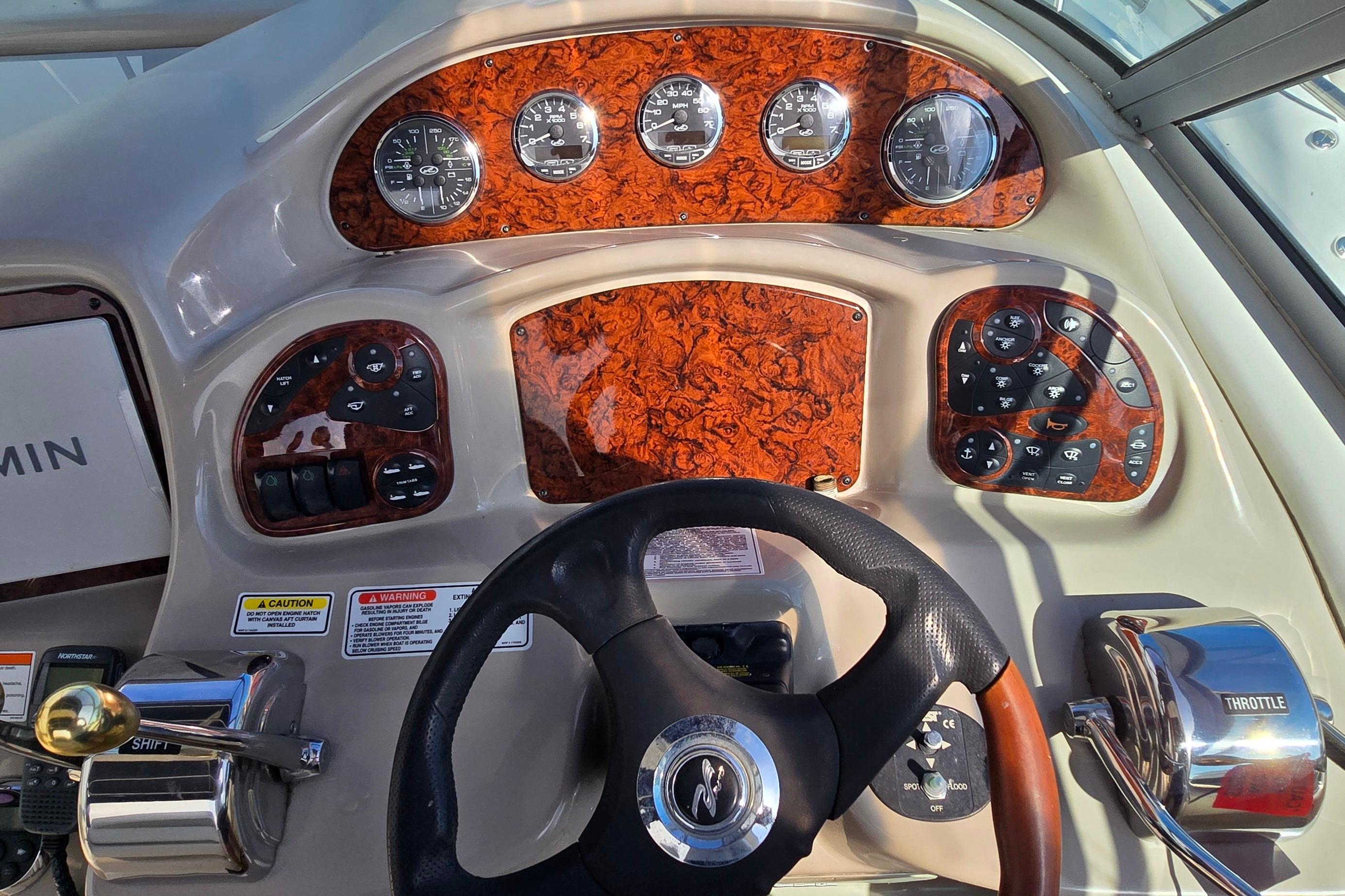 Helm of 2007 Sea Ray 340 Sundancer with woodgrain dash and modern controls.