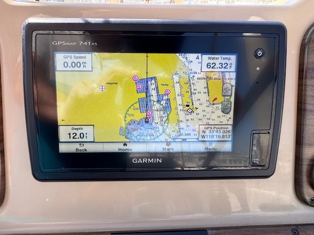 A Garmin GPS device displays a map with depth and temperature information.