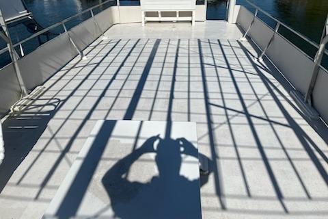 Shadow on deck of 1994 PlayCraft 5215 boat, with railing reflections.