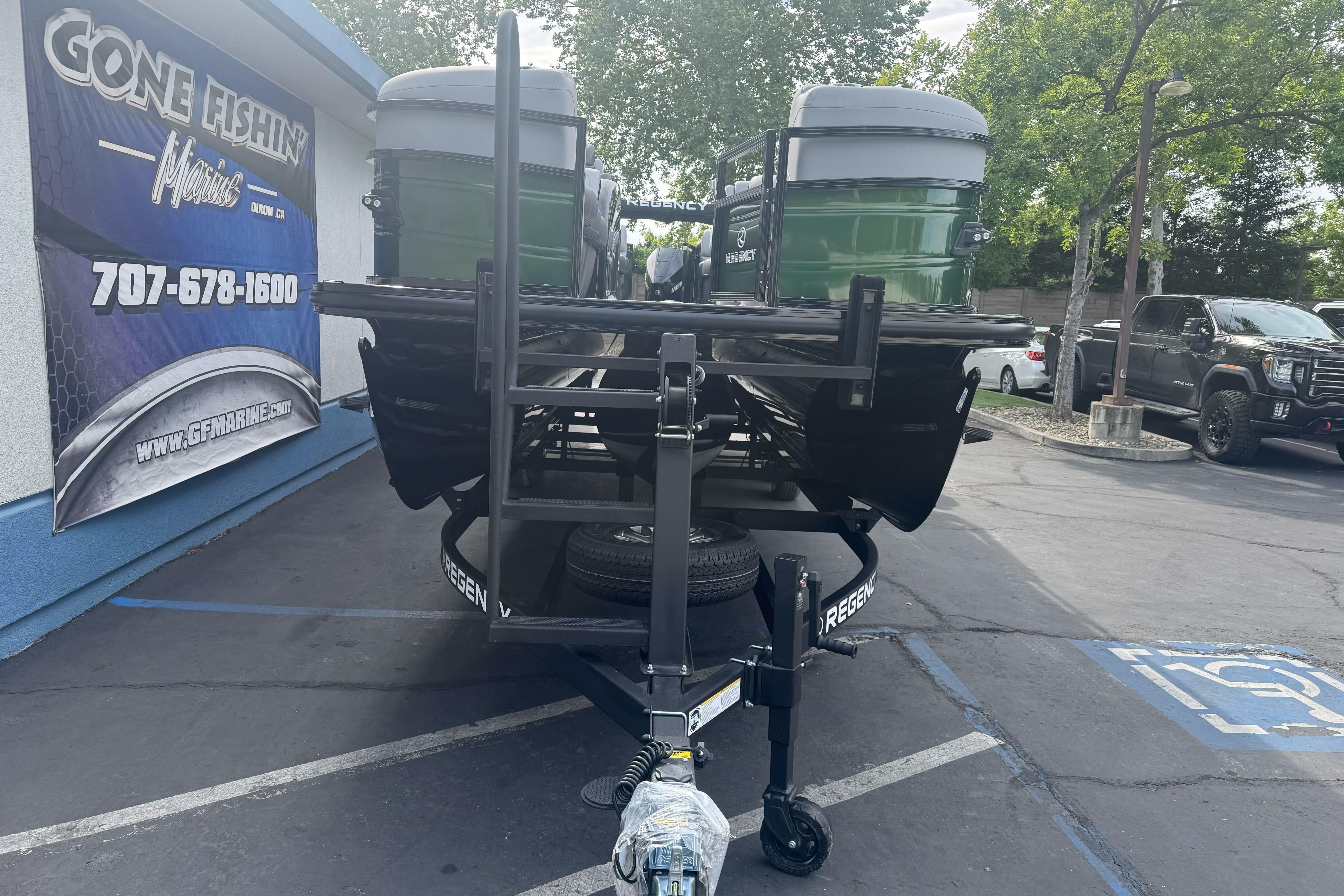 2026 Regency 250 DL boat on trailer at dealership parking lot.