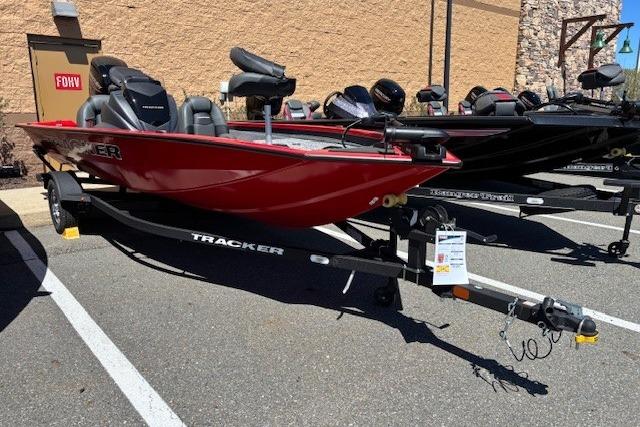 2026 Tracker Pro Team 175 boat in red, parked on a trailer in a lot.