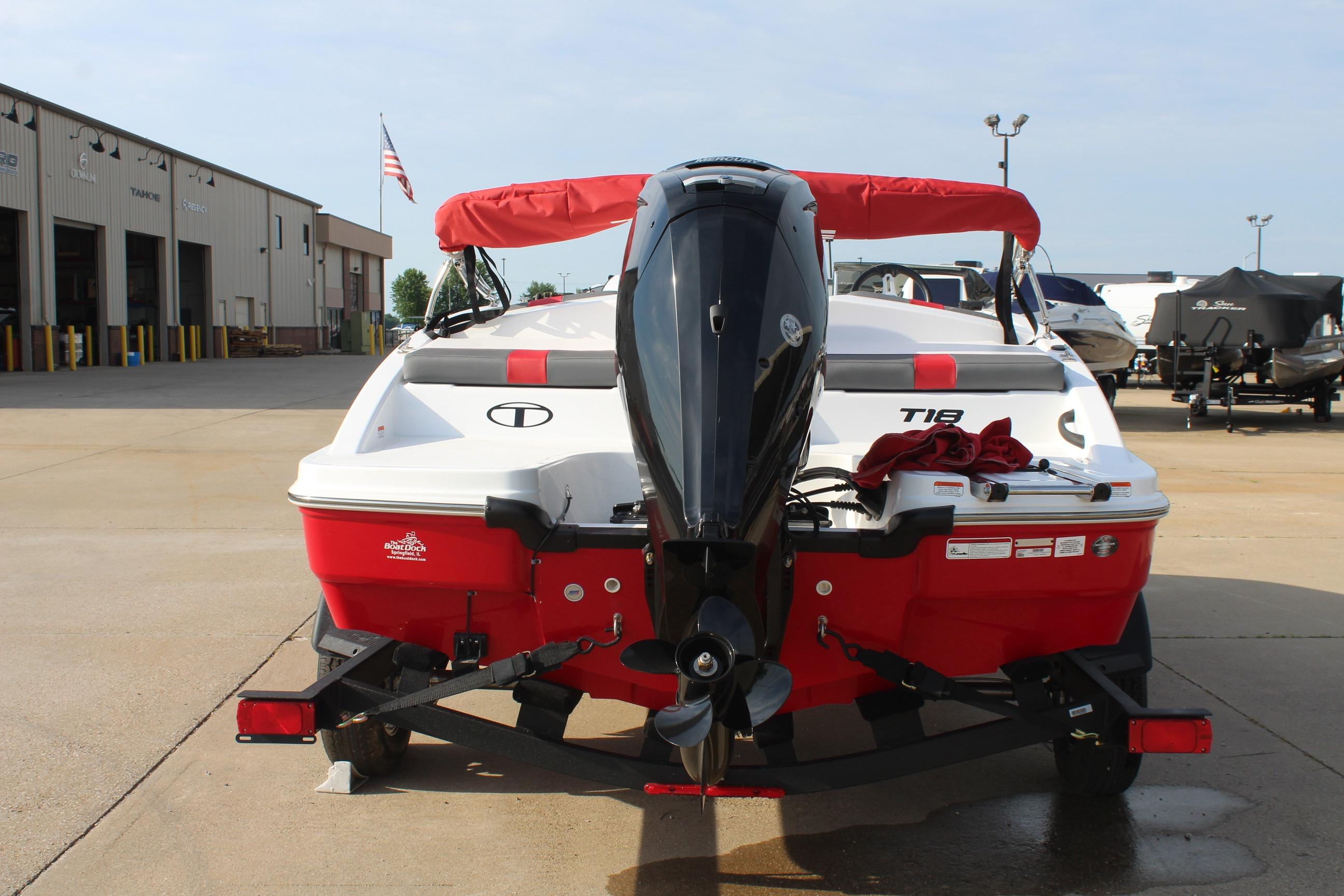 2026 Tahoe T18 boat with outboard motor, red and white design, parked outdoors.