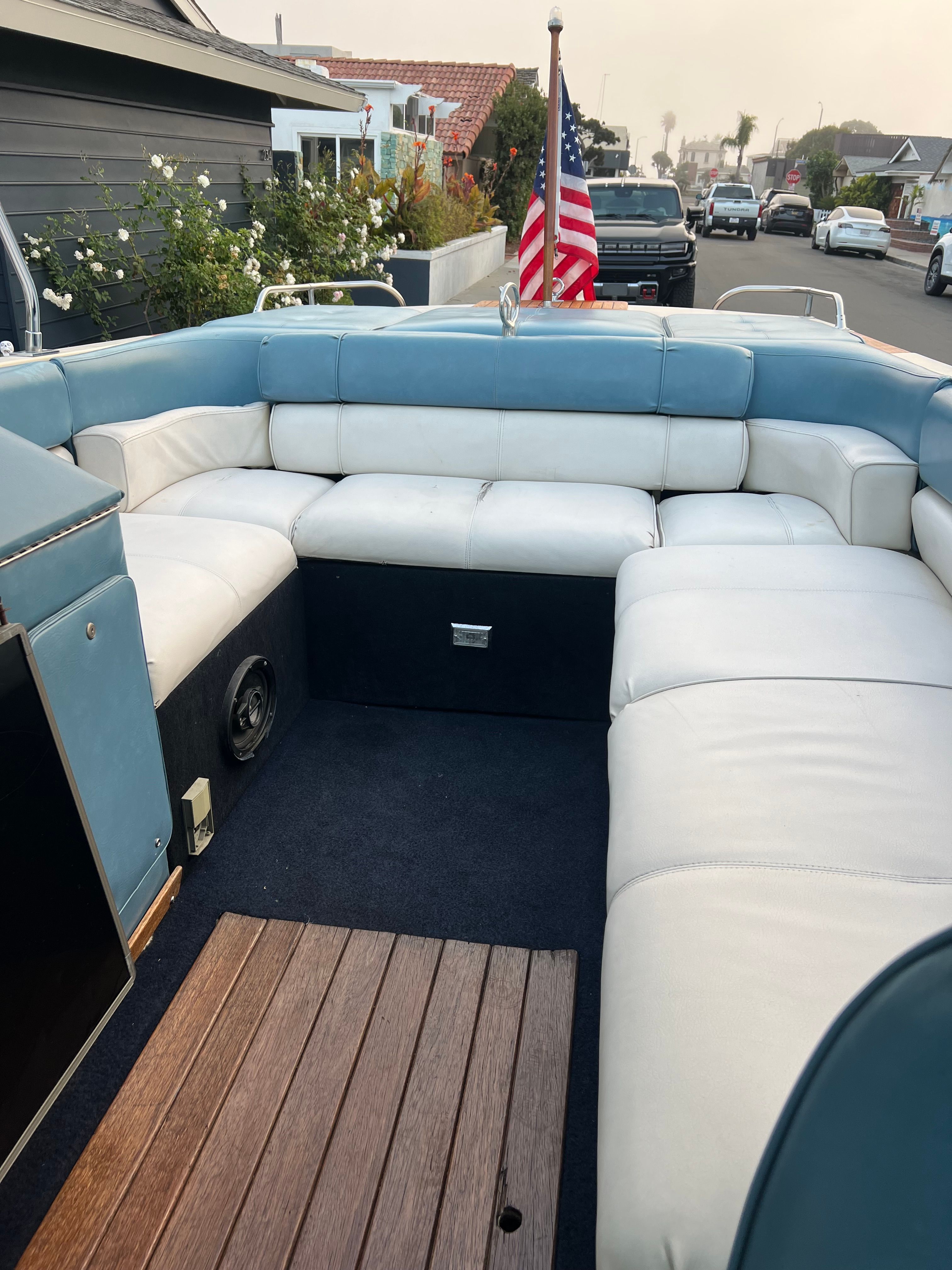 1985 Century Coronado Cardel boat interior with blue and white seating, parked on a residential street.