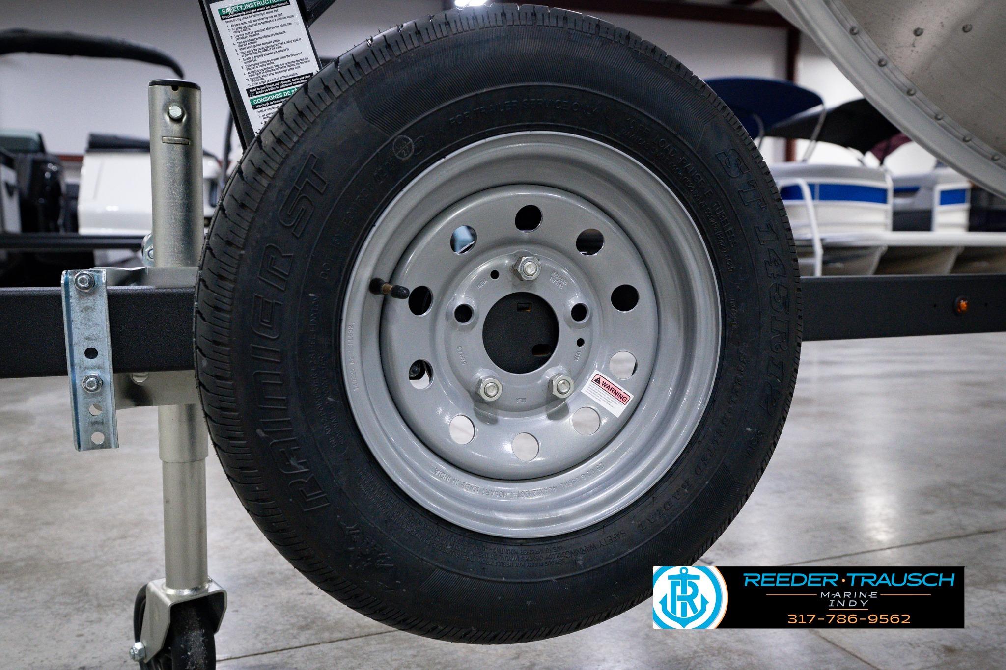 Trailer wheel of a 2026 Lund 1600 Fury SS boat, displayed indoors.
