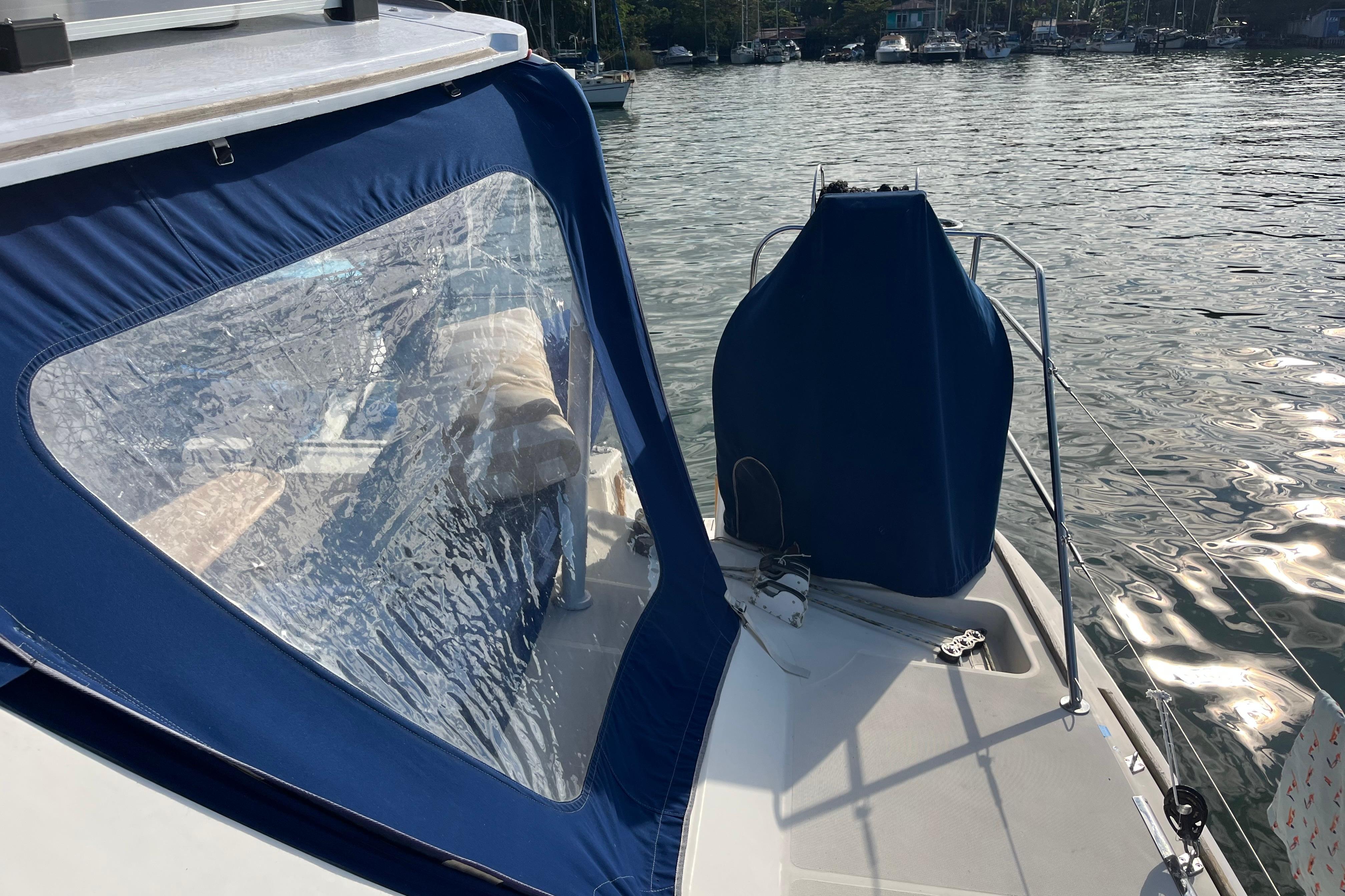 2004 Catana 471 Ocean Class sailboat with blue canopy, docked on calm water.