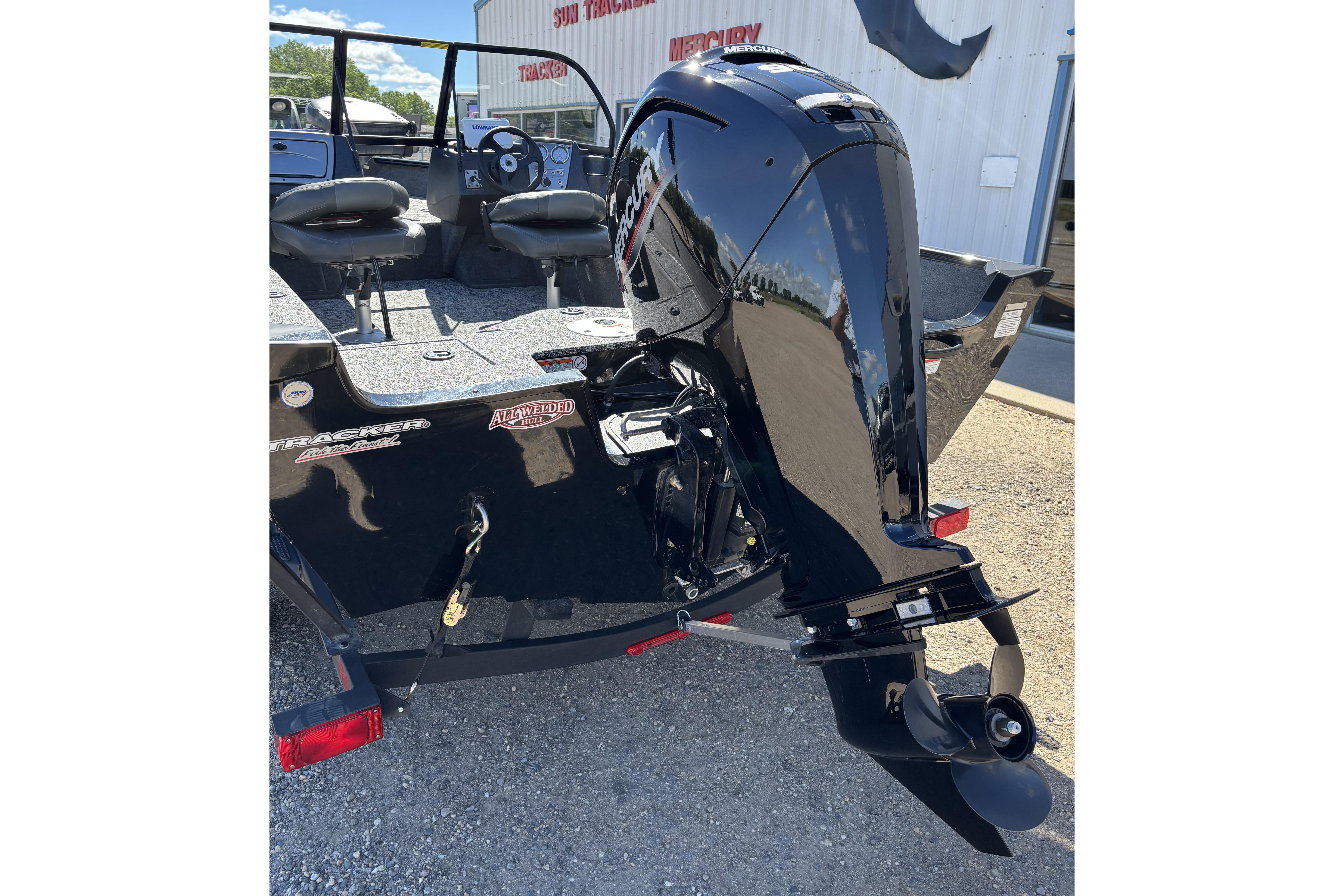 2026 Tracker Pro Guide V-16 WT boat with Mercury outboard motor, parked outdoors.