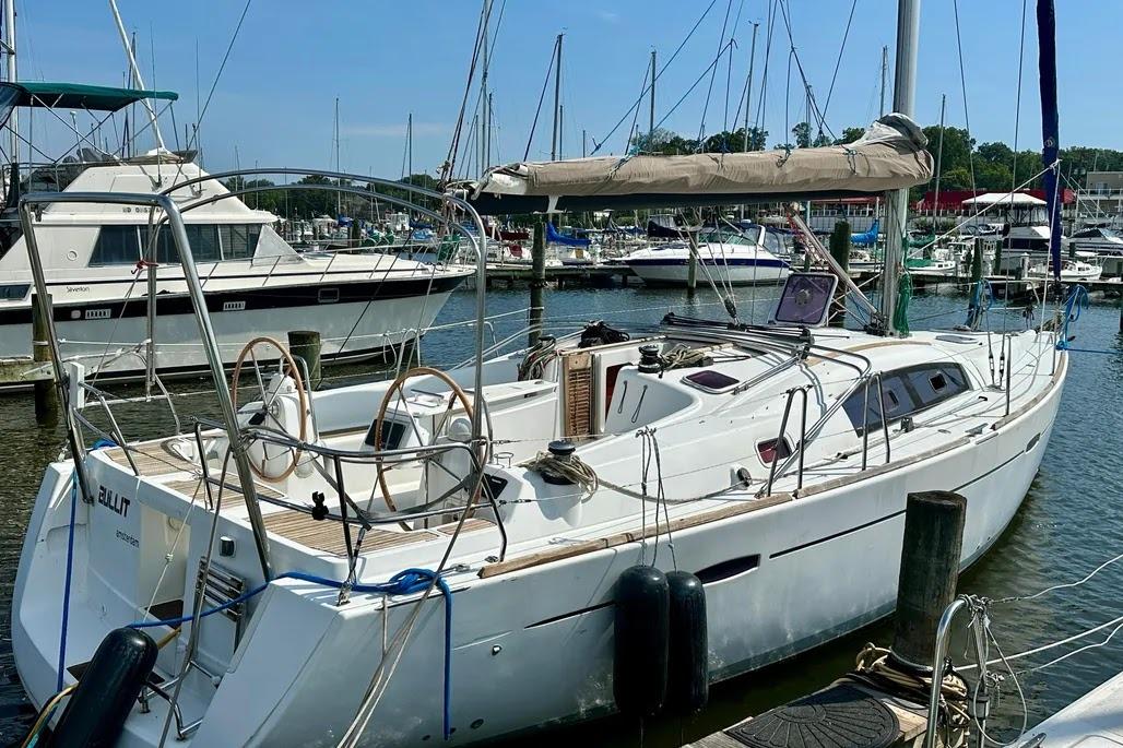 2011 Beneteau Oceanis 40 sailboat docked in a marina, featuring dual steering wheels.