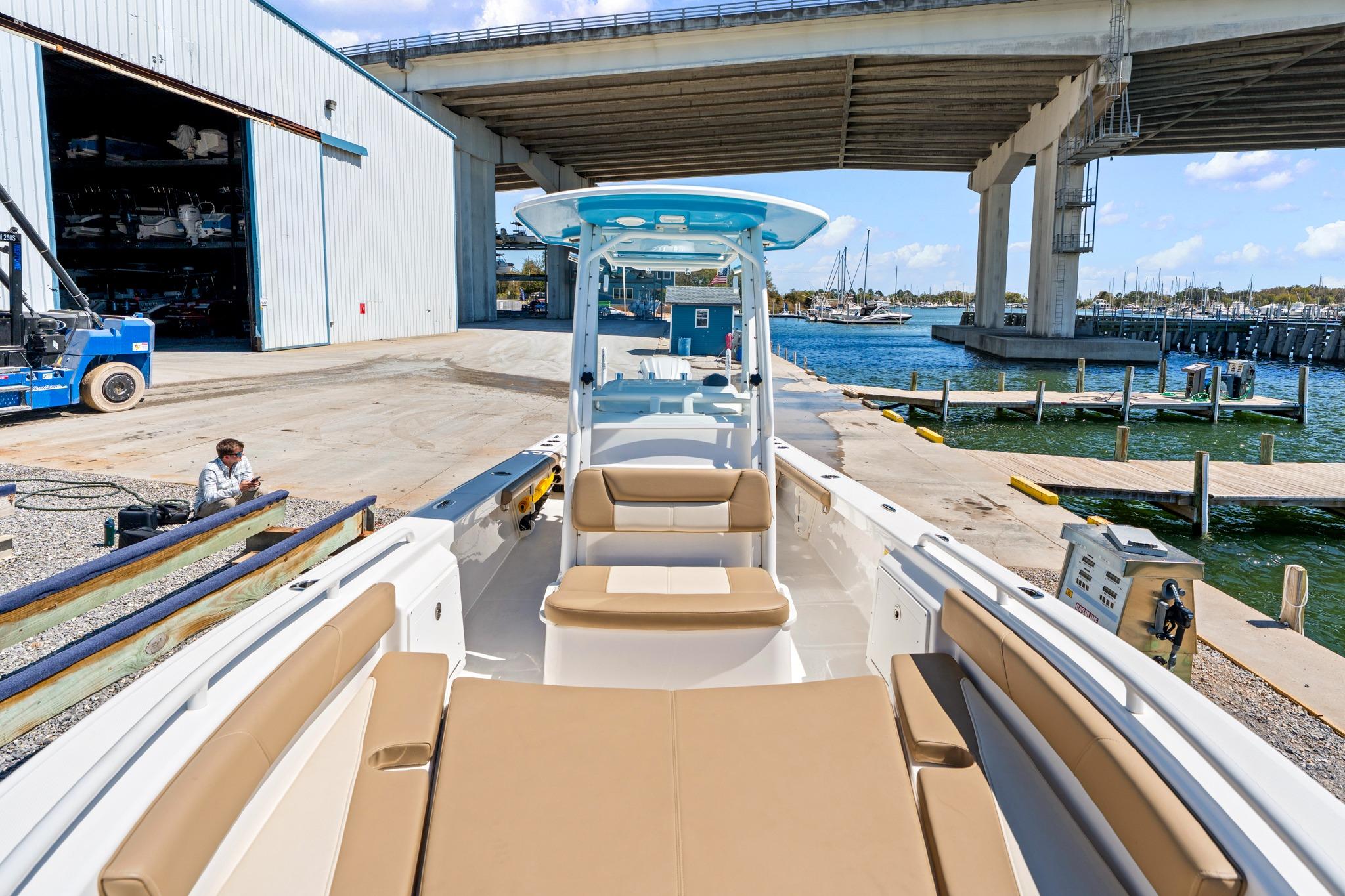 2023 Everglades 243 Center Console boat docked near marina under bridge.