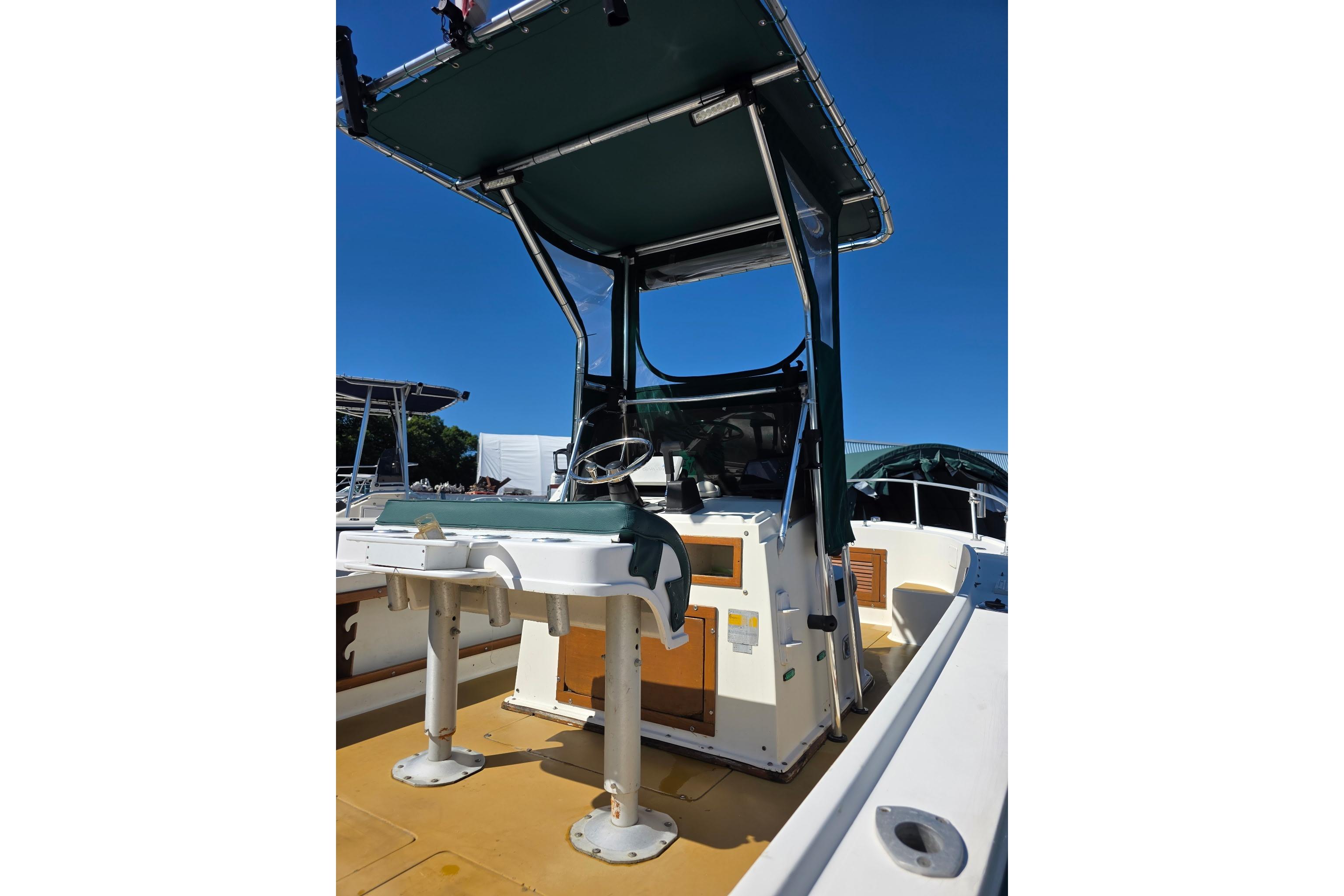 1982 Mako 20 Center Console boat with canopy and steering wheel.