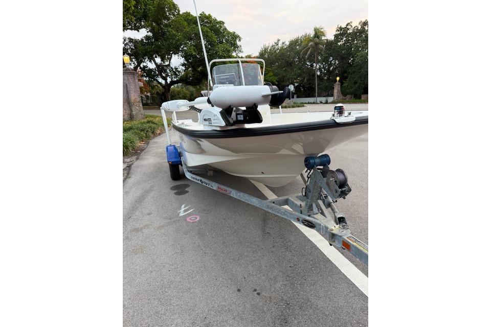 2016 Boston Whaler 150 Montauk boat on trailer, parked on a street.