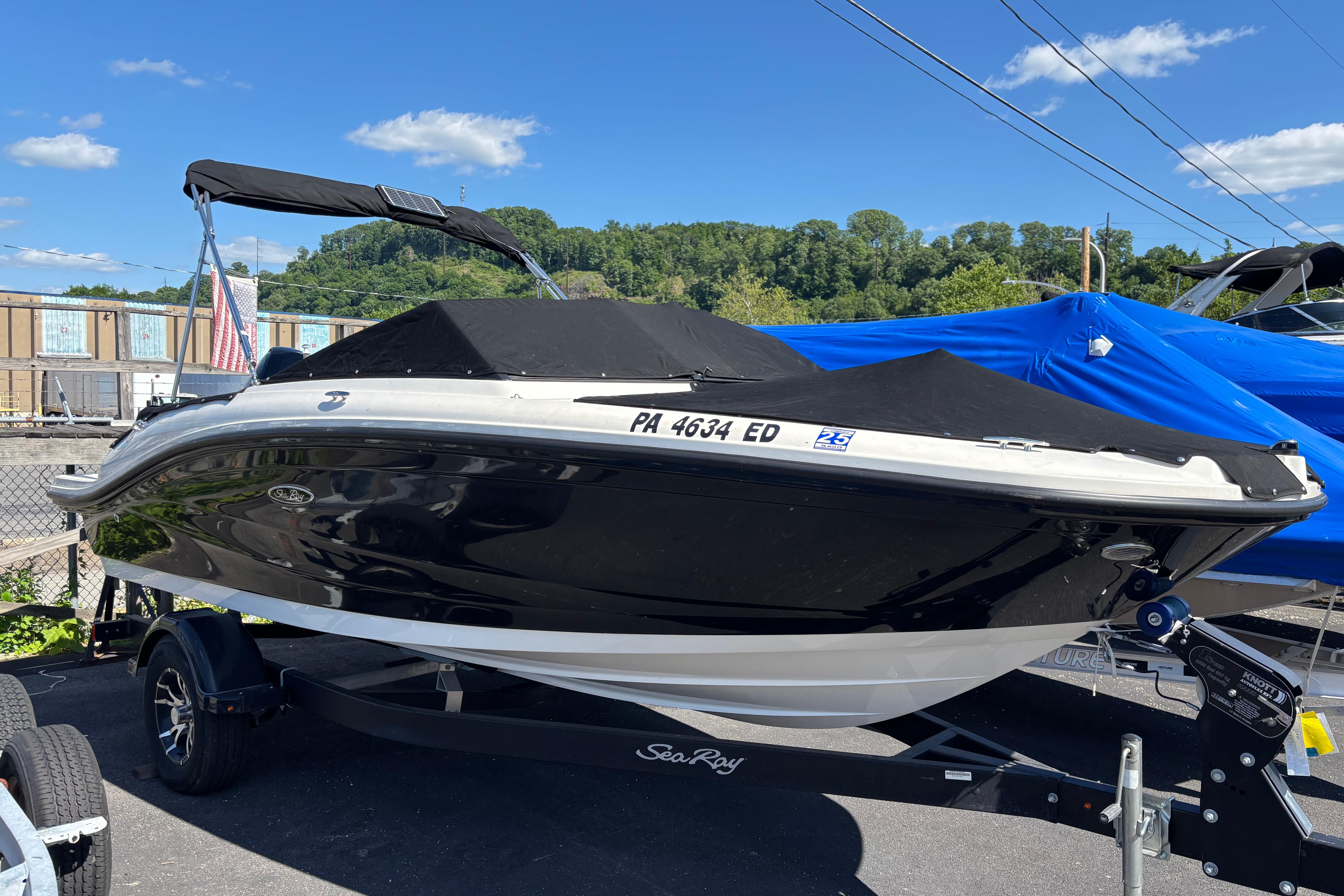 2022 Sea Ray SPX 190 Outboard boat with black cover on trailer, sunny day.