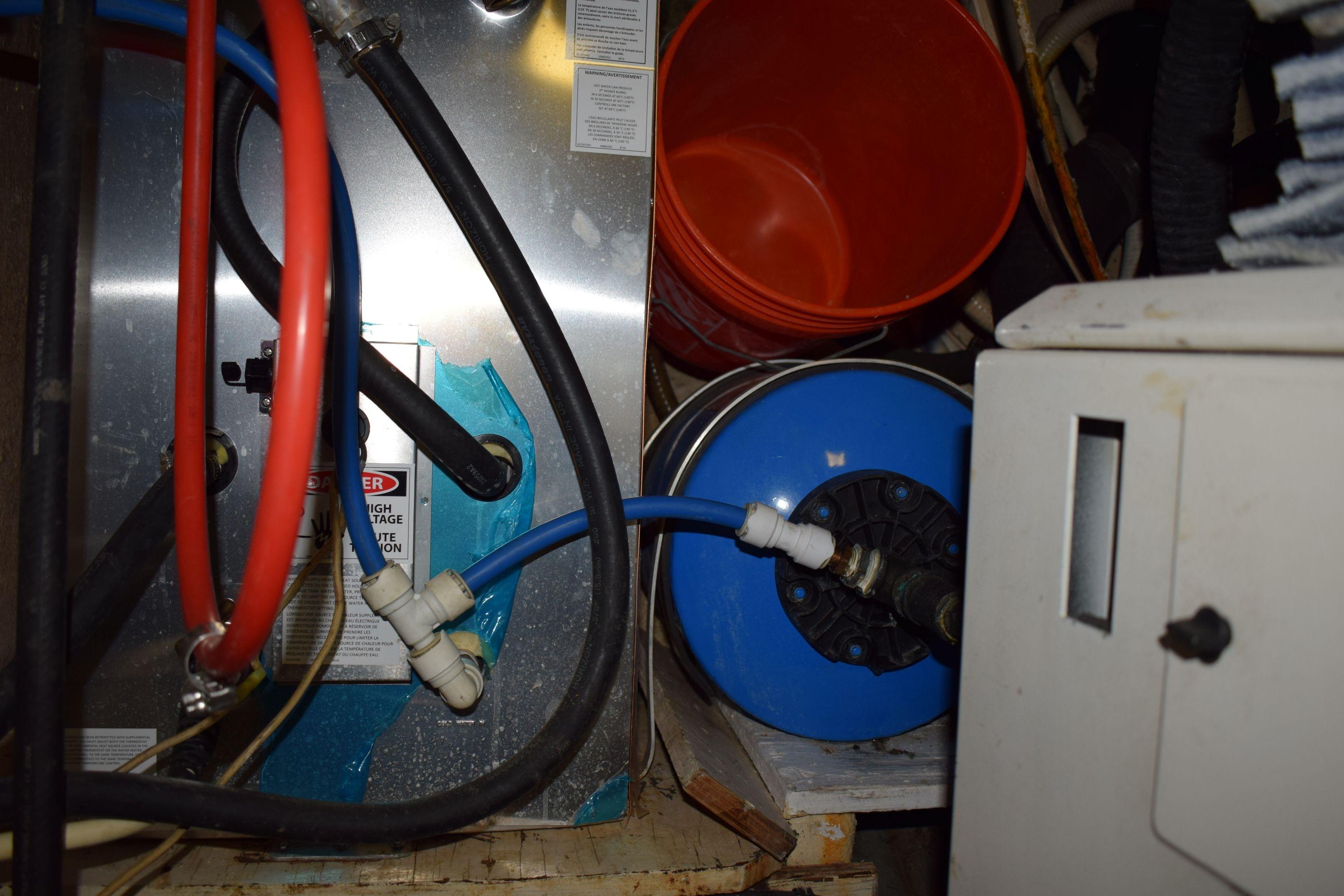 Engine room of 1980 Cheoy Lee 52 Motorsailer with hoses and equipment.