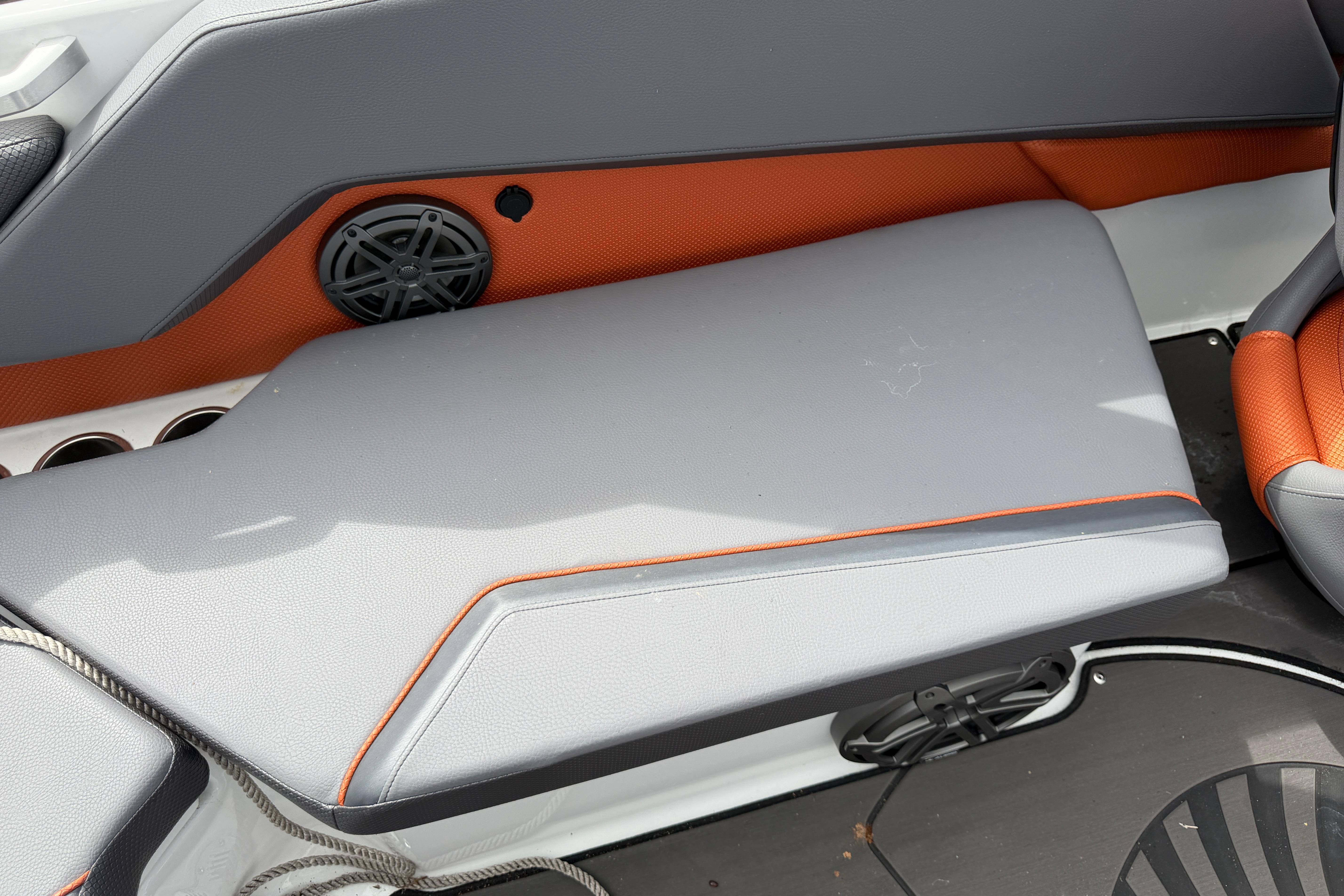 2026 Scarab 235 LX boat interior with gray and orange seating, speaker, and cup holders.