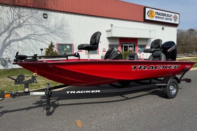 2026 Tracker Pro Team 175 boat in red, parked outside a service center.
