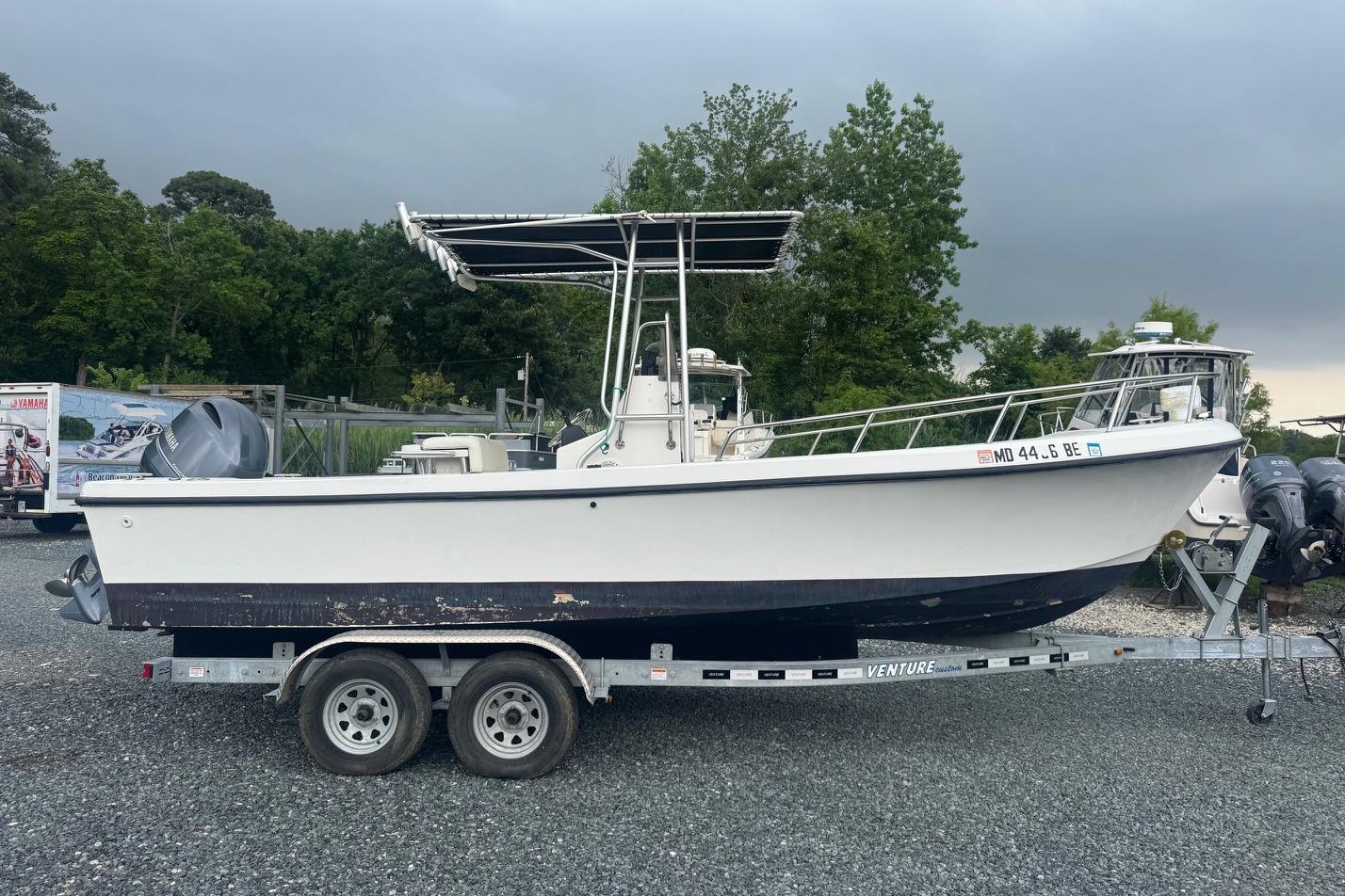 1997 Maycraft 23 boat on trailer, parked outdoors with trees in background.