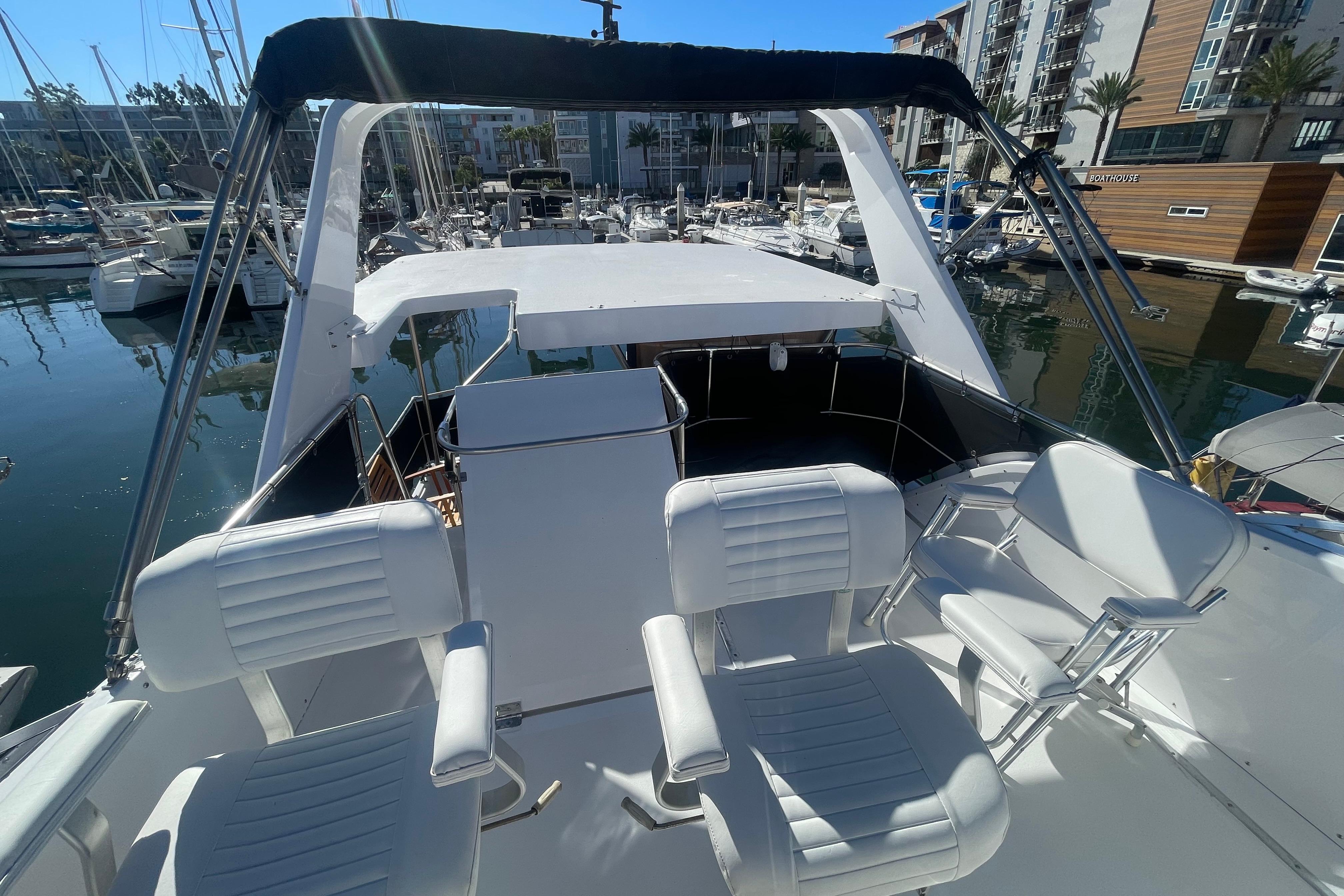 1975 Uniflite Aft Cabin yacht with new bridge helm seating, docked in a marina.