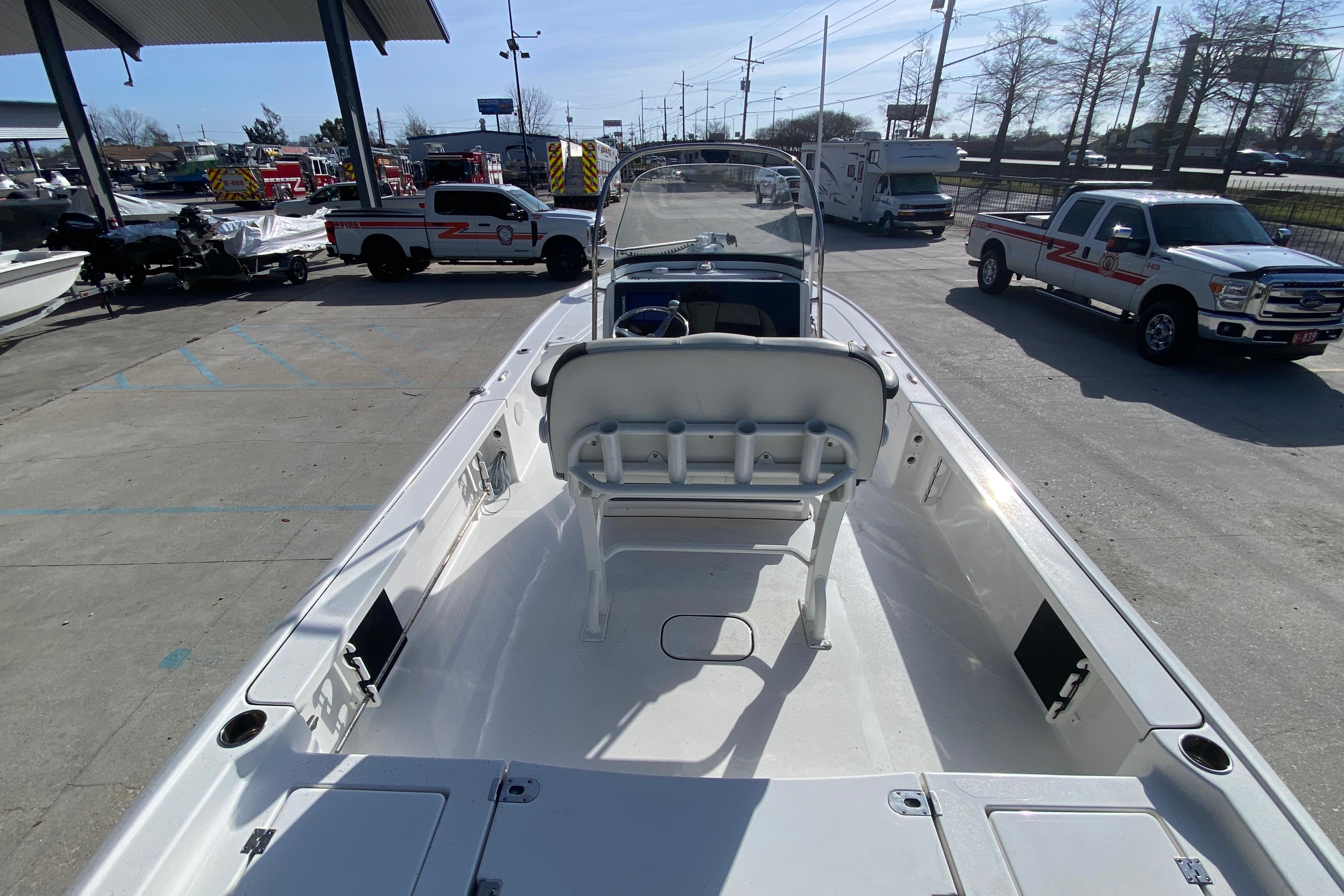 2023 Tidewater 2410 Bay Max boat interior at a dealership with trucks in the background.