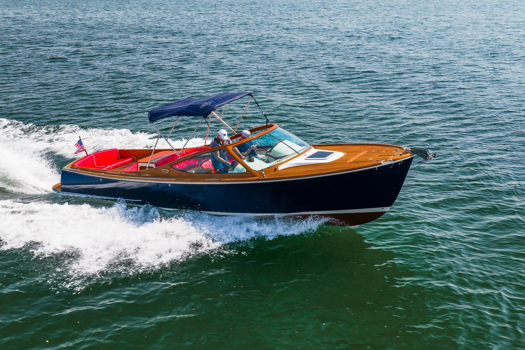 2005 Hinckley Talaria 29R cruising on open water with passengers, featuring sleek design and vibrant colors.