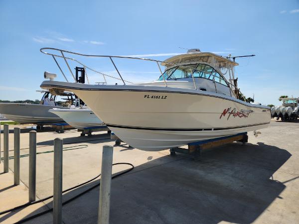 2005 Pursuit 3070 Offshore Center Console boat on dry dock, sunny day.