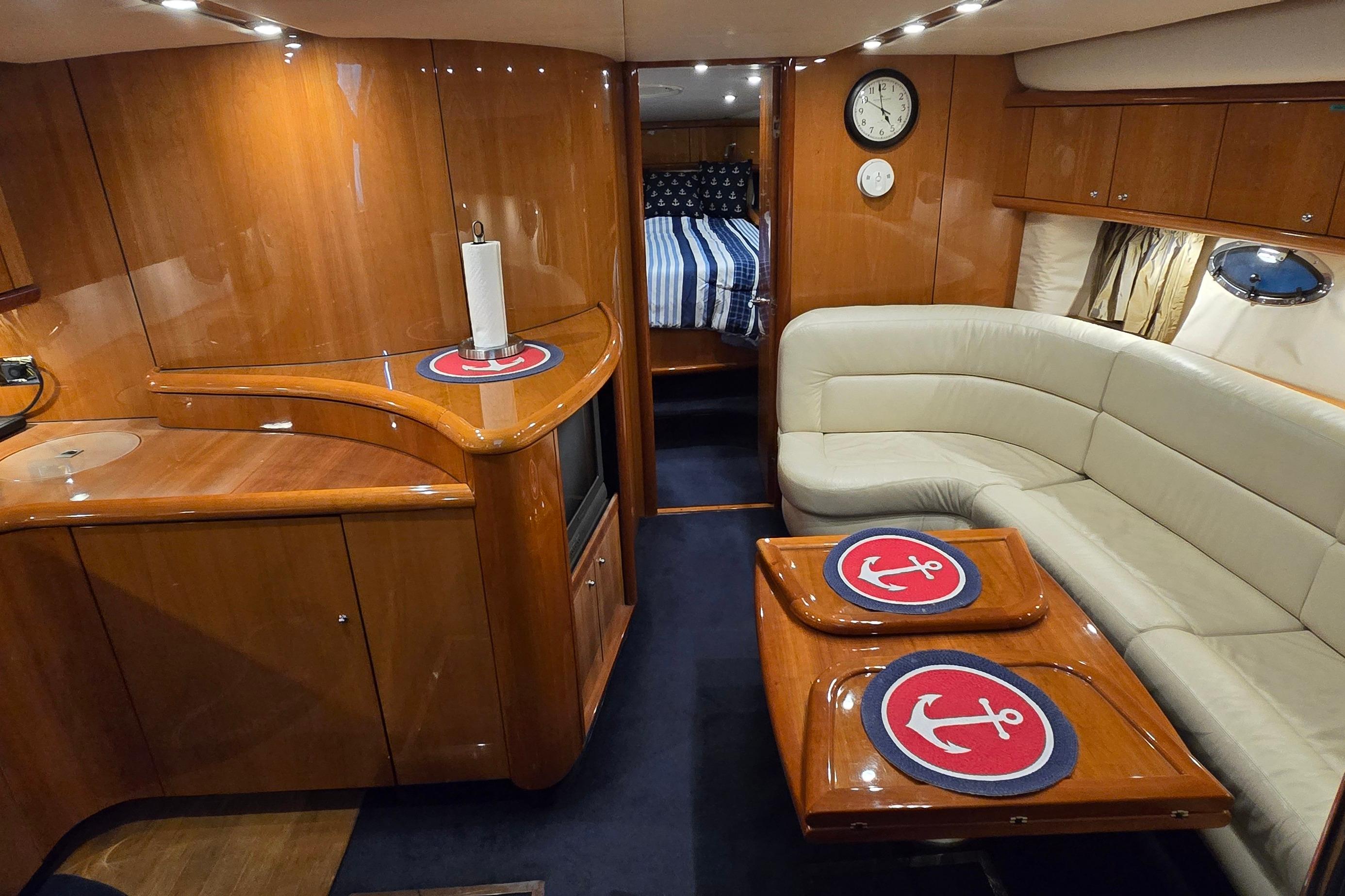 Luxurious interior of 2004 Sunseeker Camargue 50 yacht with elegant wood finish and cozy seating.