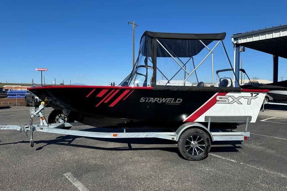 2026 Starweld 17 SXT boat on trailer, black with red accents, parked outdoors.