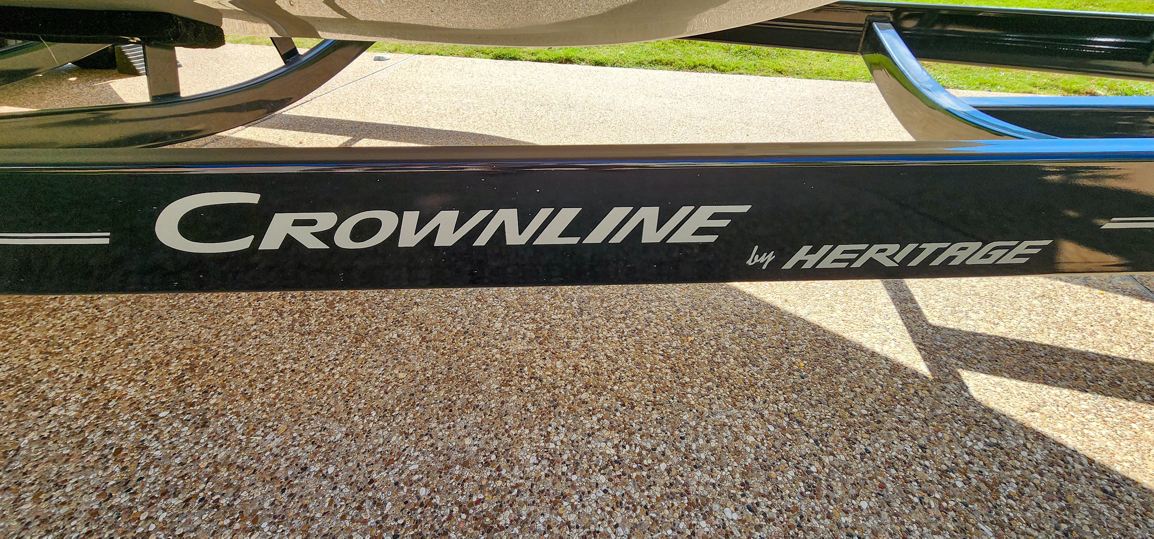 Close-up of the Crownline 285SS boat trailer on a gravel path.
