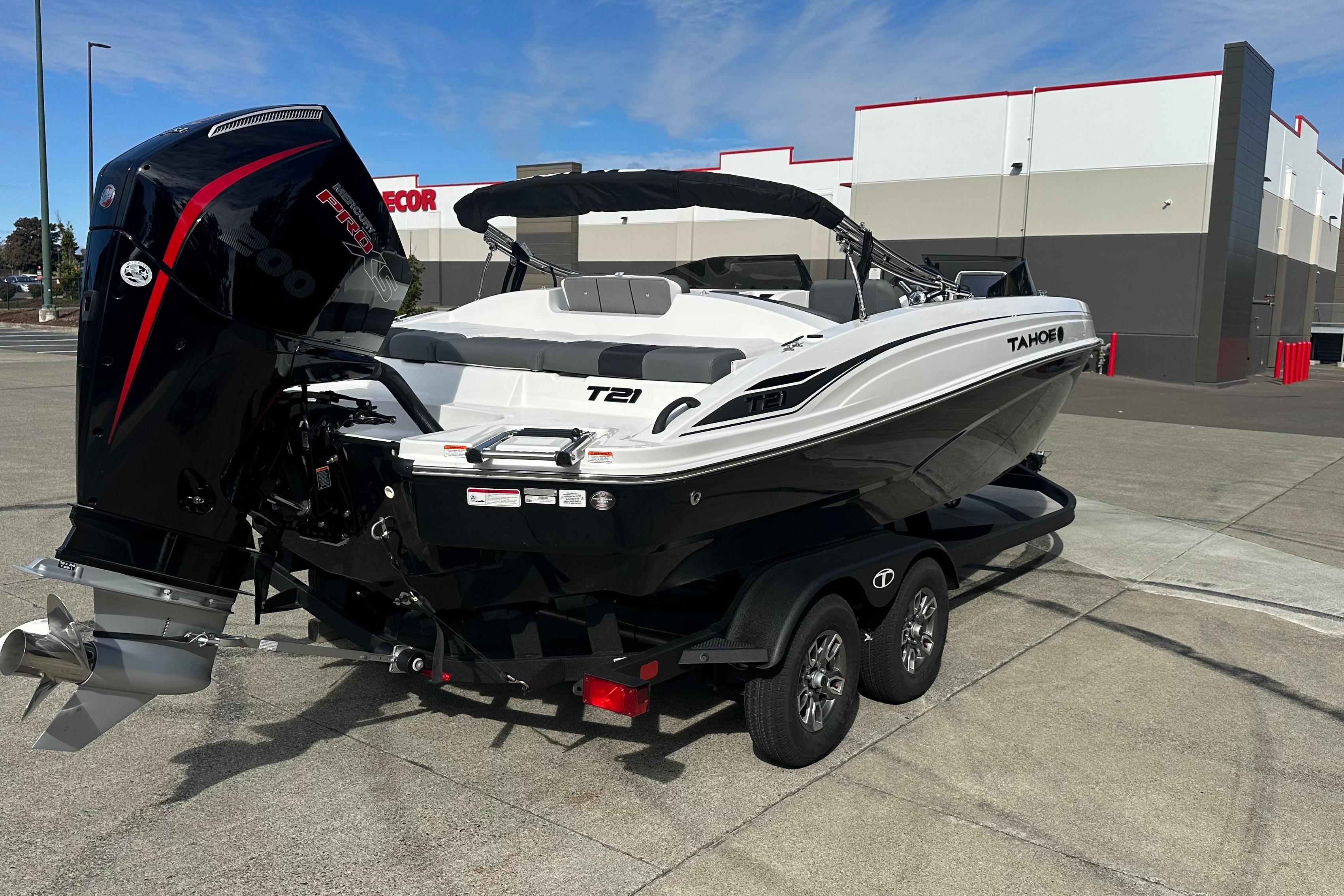 2026 Tahoe T21 boat on trailer, parked outdoors, featuring sleek design and powerful engine.