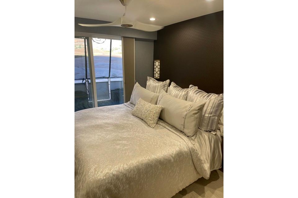 Luxurious bedroom with elegant bedding and balcony view on Adonia's 2021 "The Queen Elizabeth."