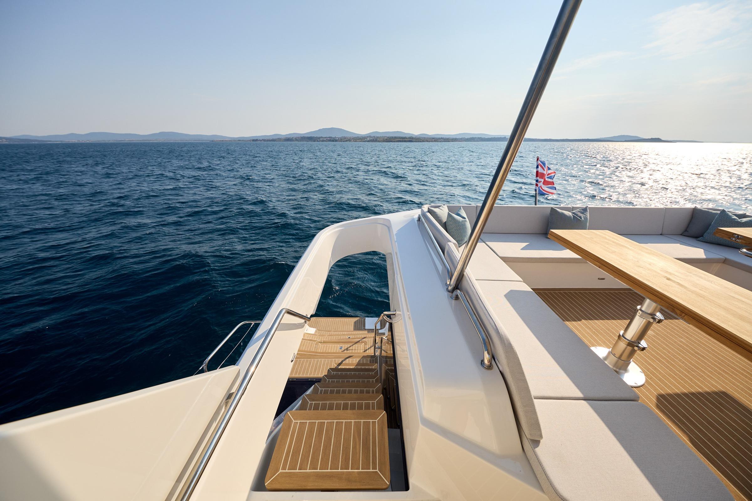 Luxurious 2025 Omaya 50 Power Catamaran deck with seating, table, and ocean view.