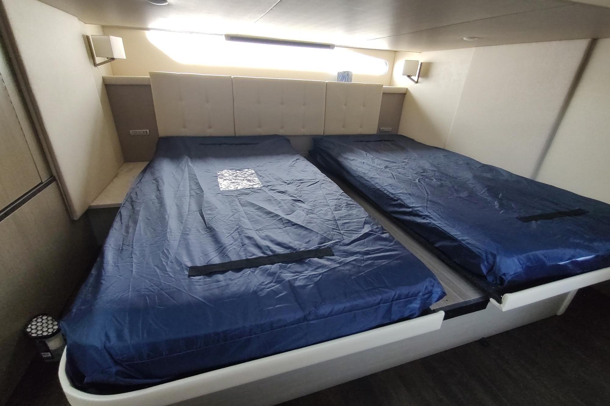 Interior cabin of 2021 Regal 42 Fly yacht with twin beds and blue bedding.