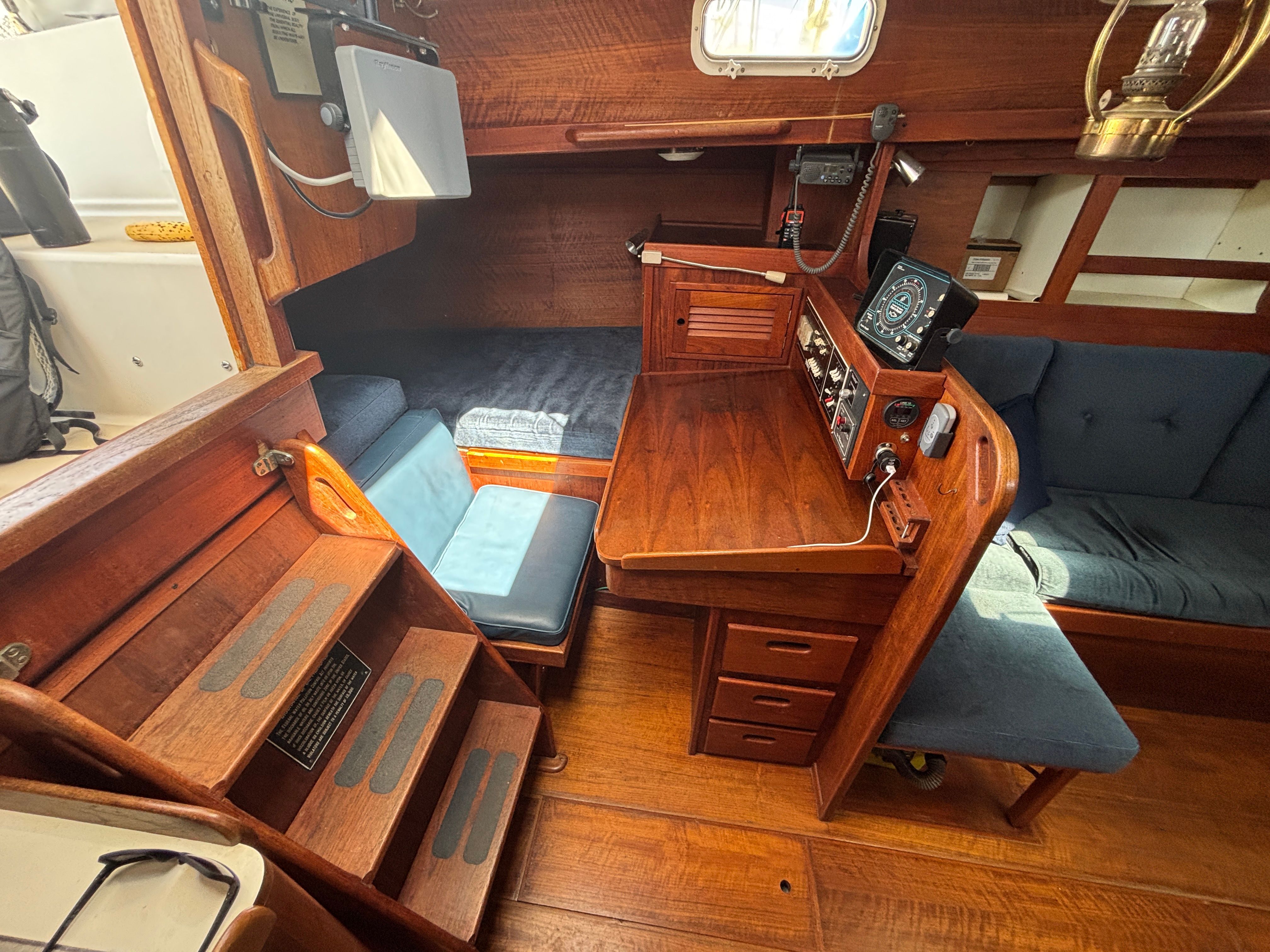 Interior of a 1979 Tartan 37 with wooden furnishings and blue upholstery.