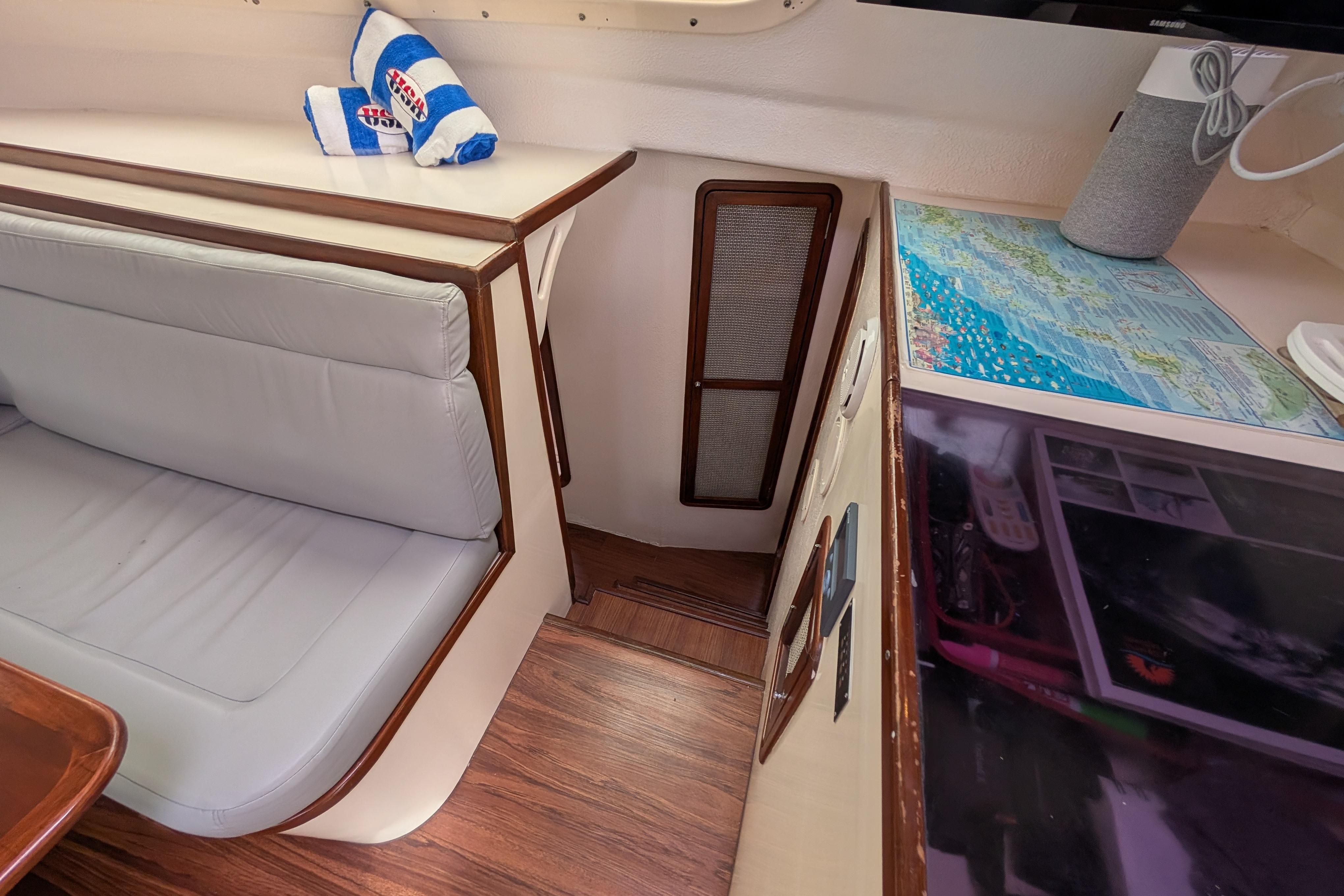 Interior of 1999 Island Spirit 37 yacht with seating, map, and wooden flooring.