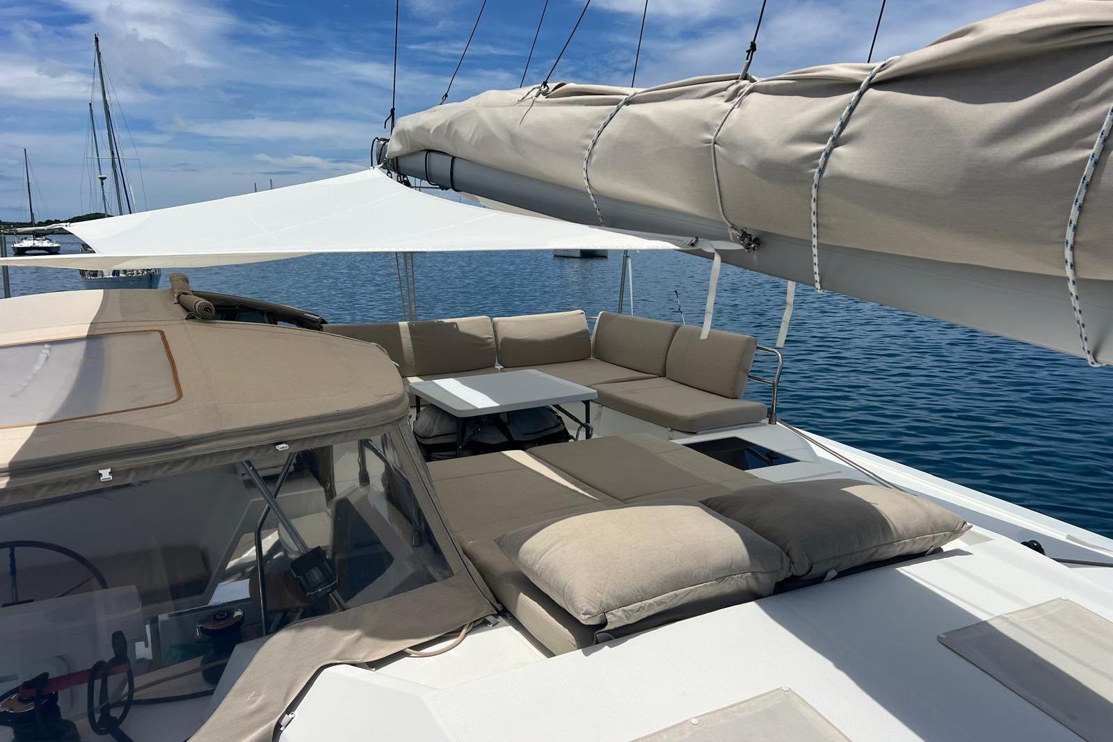 2022 Fountaine Pajot Elba 45 Catamaran with spacious deck and seating, anchored on calm water.