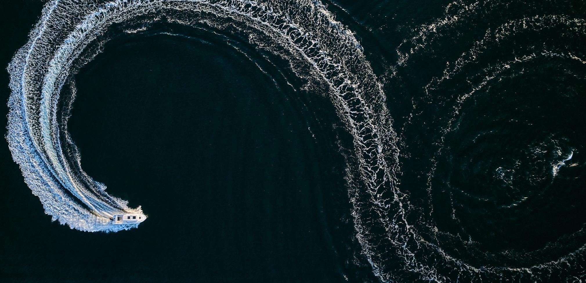 Aerial view of 2024 Skamander 920 Explorer MAX creating circular wake patterns on water.