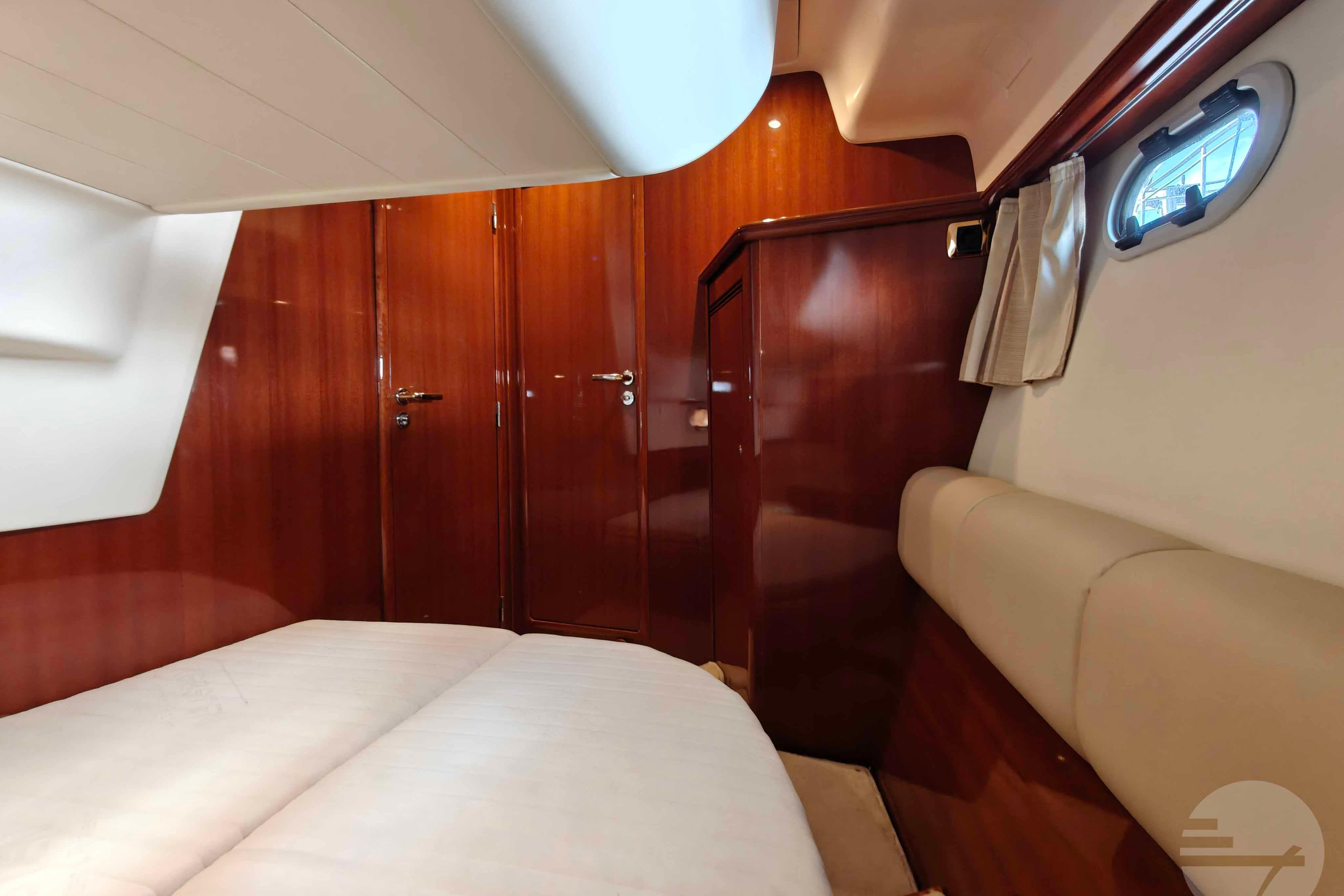 Interior cabin of 2006 Jeanneau Prestige 46 yacht with wood paneling and cozy seating.