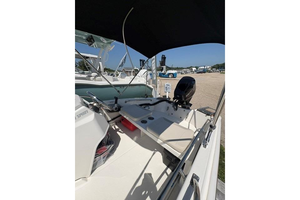 2024 Boston Whaler 130 Super Sport boat interior with seating and motor, parked outdoors.