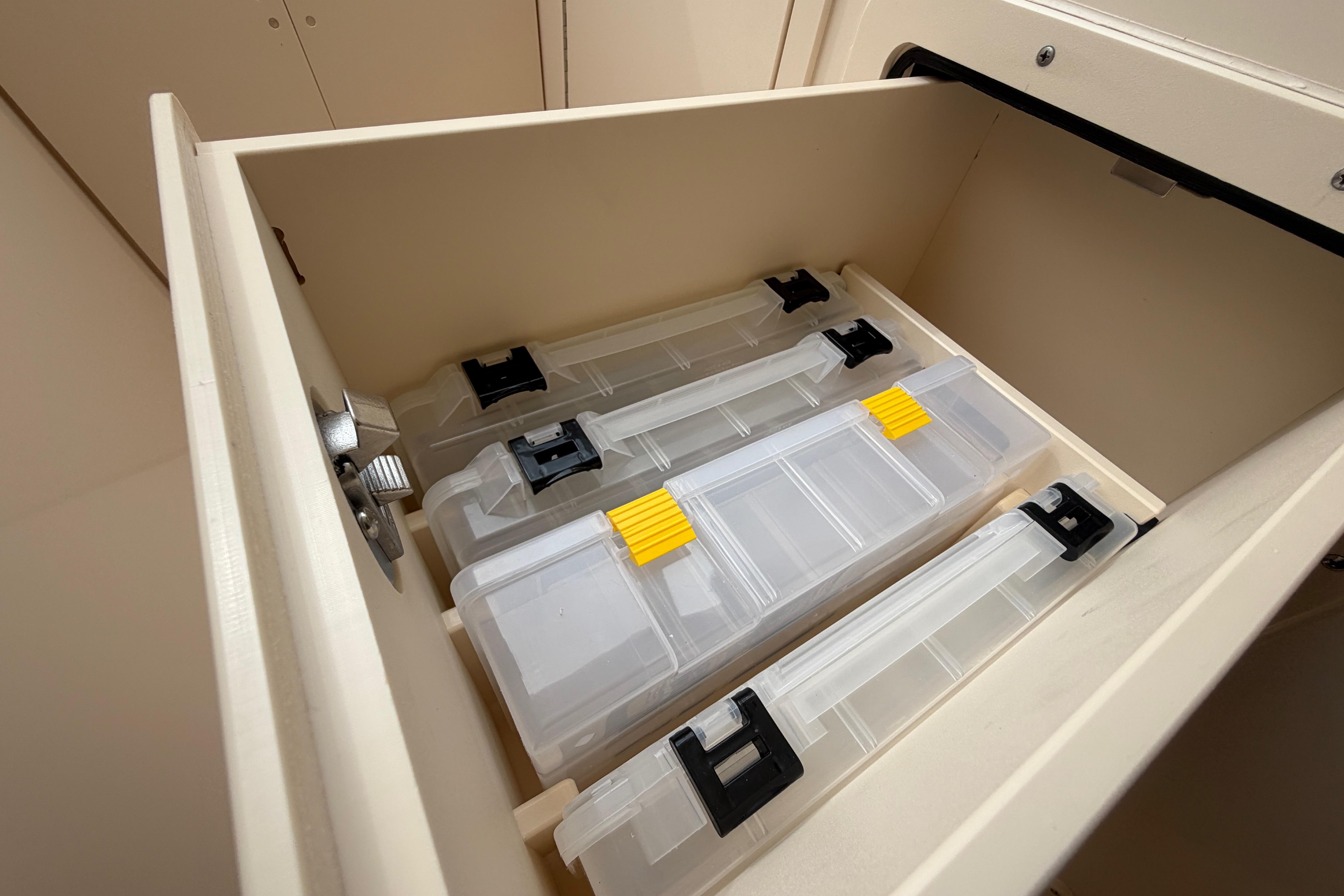 Storage compartment with tackle boxes in a 2019 Grady-White Freedom 307 boat.