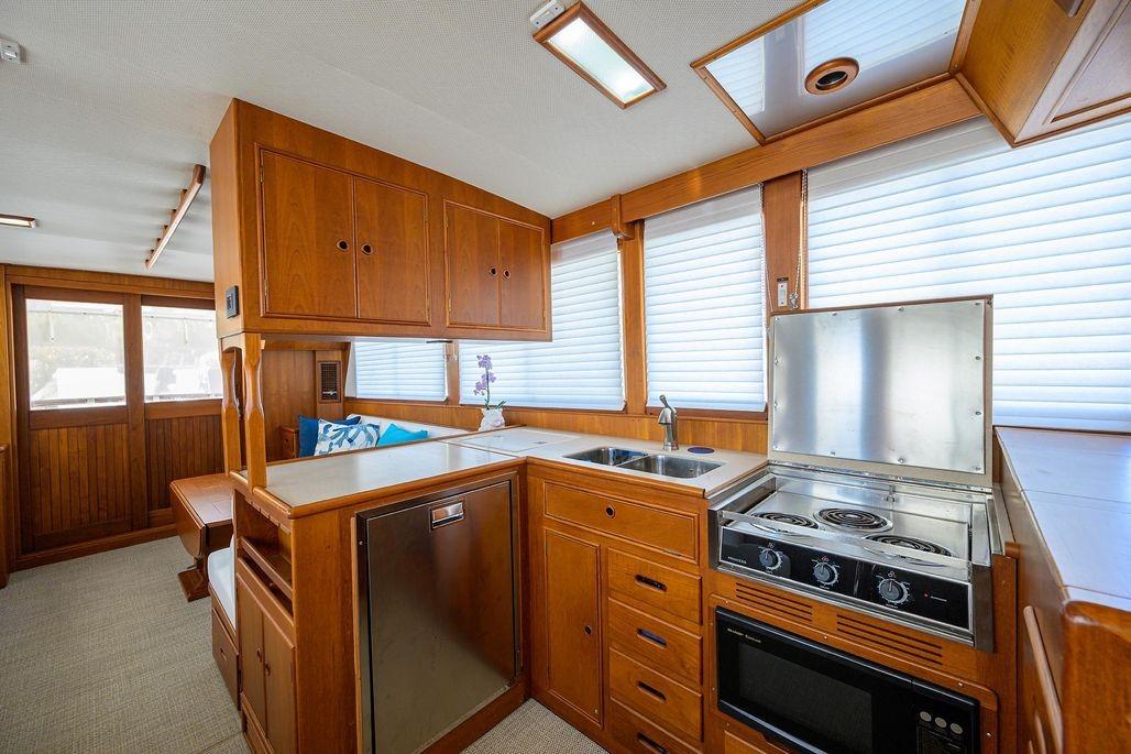 Interior of 1999 Grand Banks 42 Europa yacht with wooden cabinetry and modern kitchen amenities.
